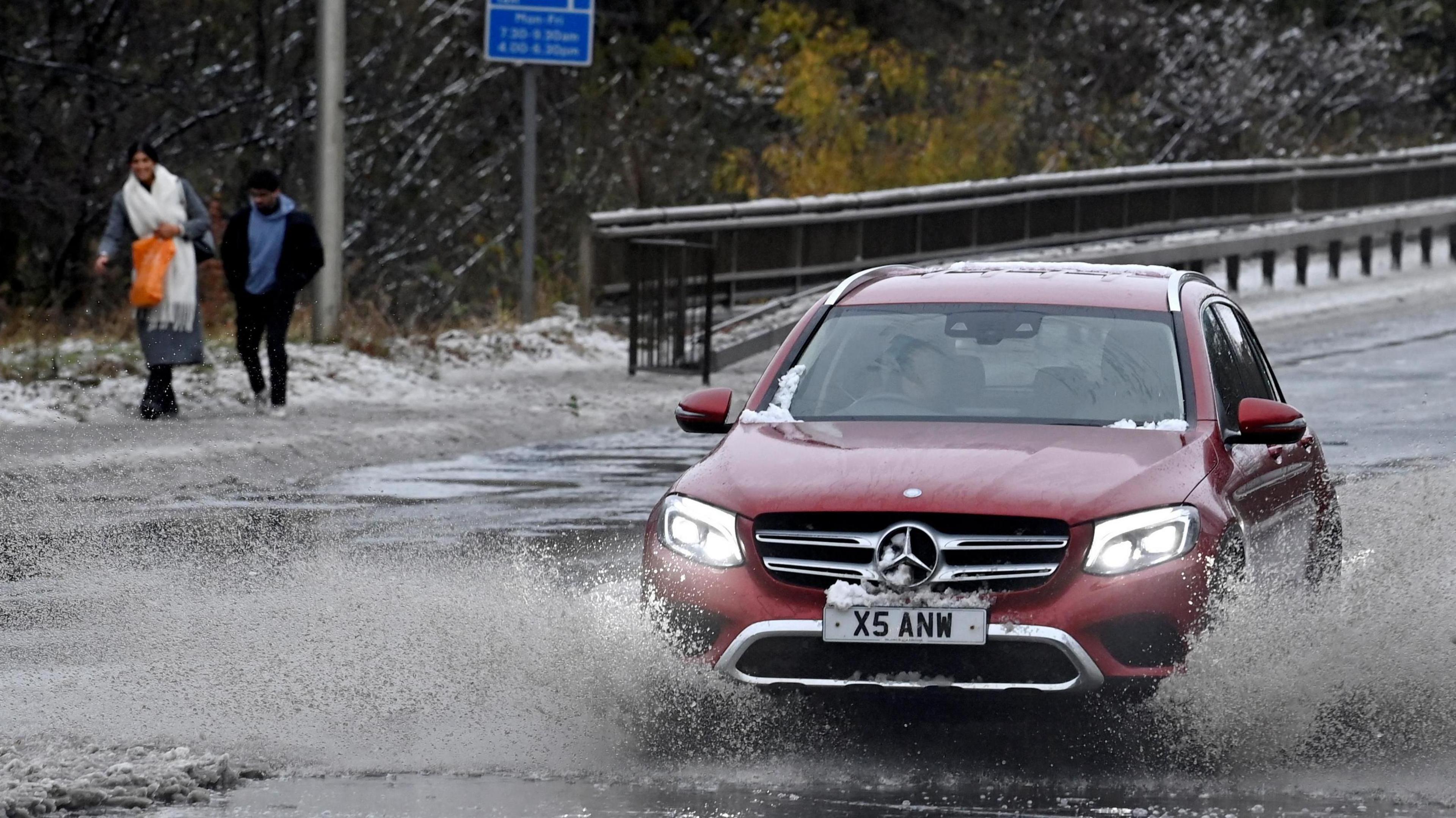 A car drives through water along the A90, as a result of Storm Bert, in Cramond near Edinburgh