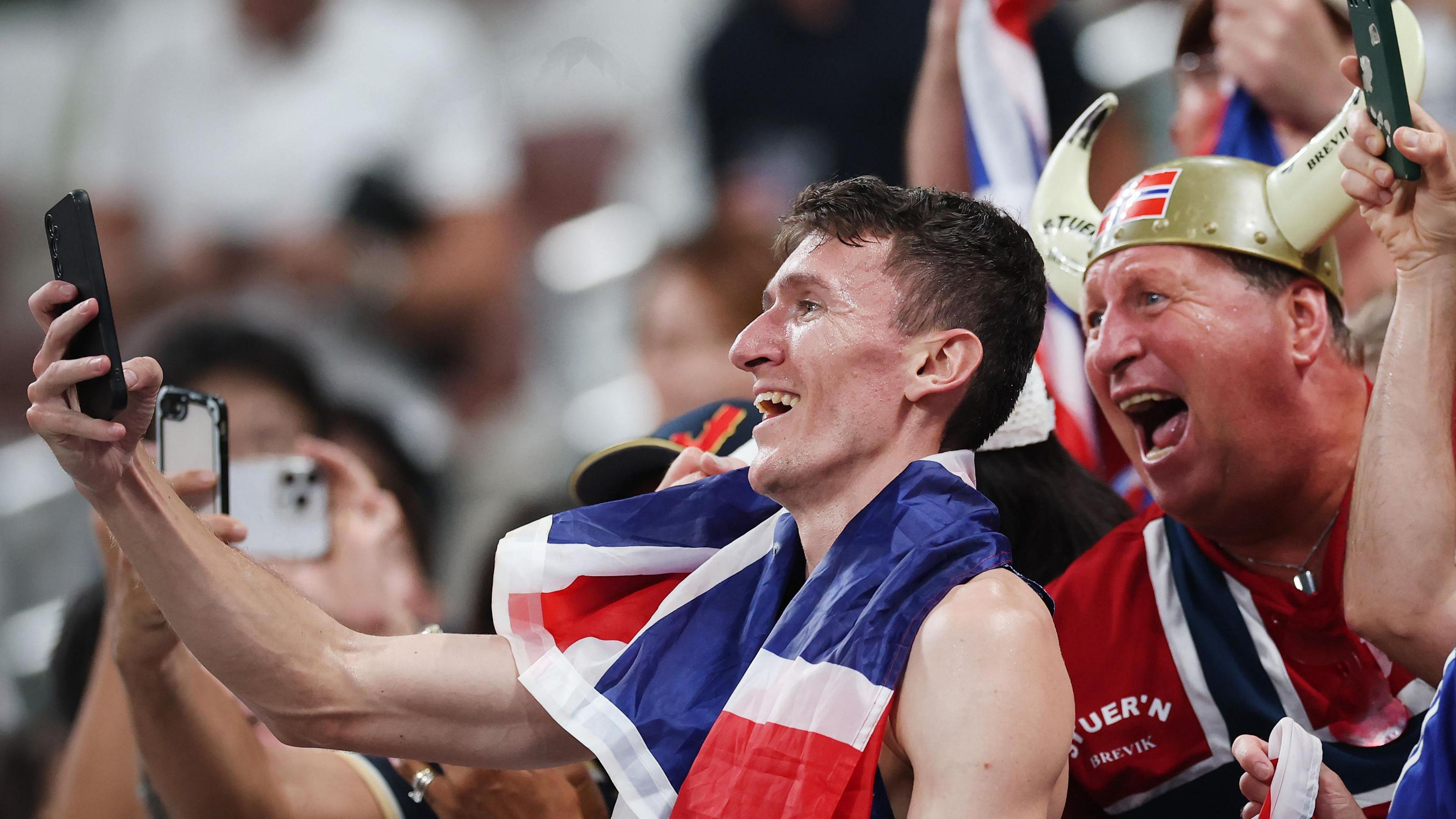 Jake Wightman celebrates with British fans after his silver