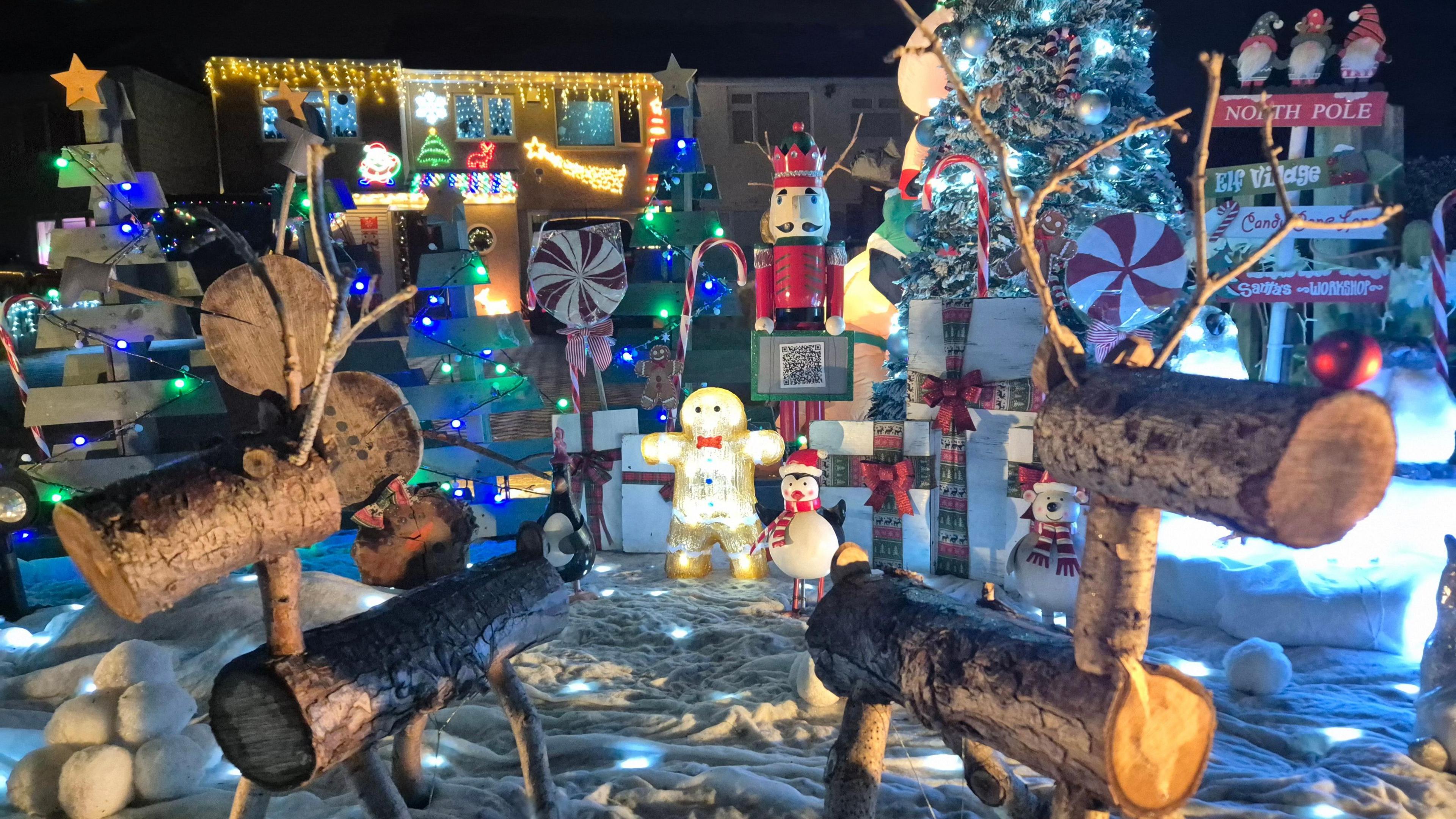 A Christmas display in Bristol. Reindeers can be seen, made out of logs and sticks. There are also lights, nutcrackers and Christmas trees in the image. 