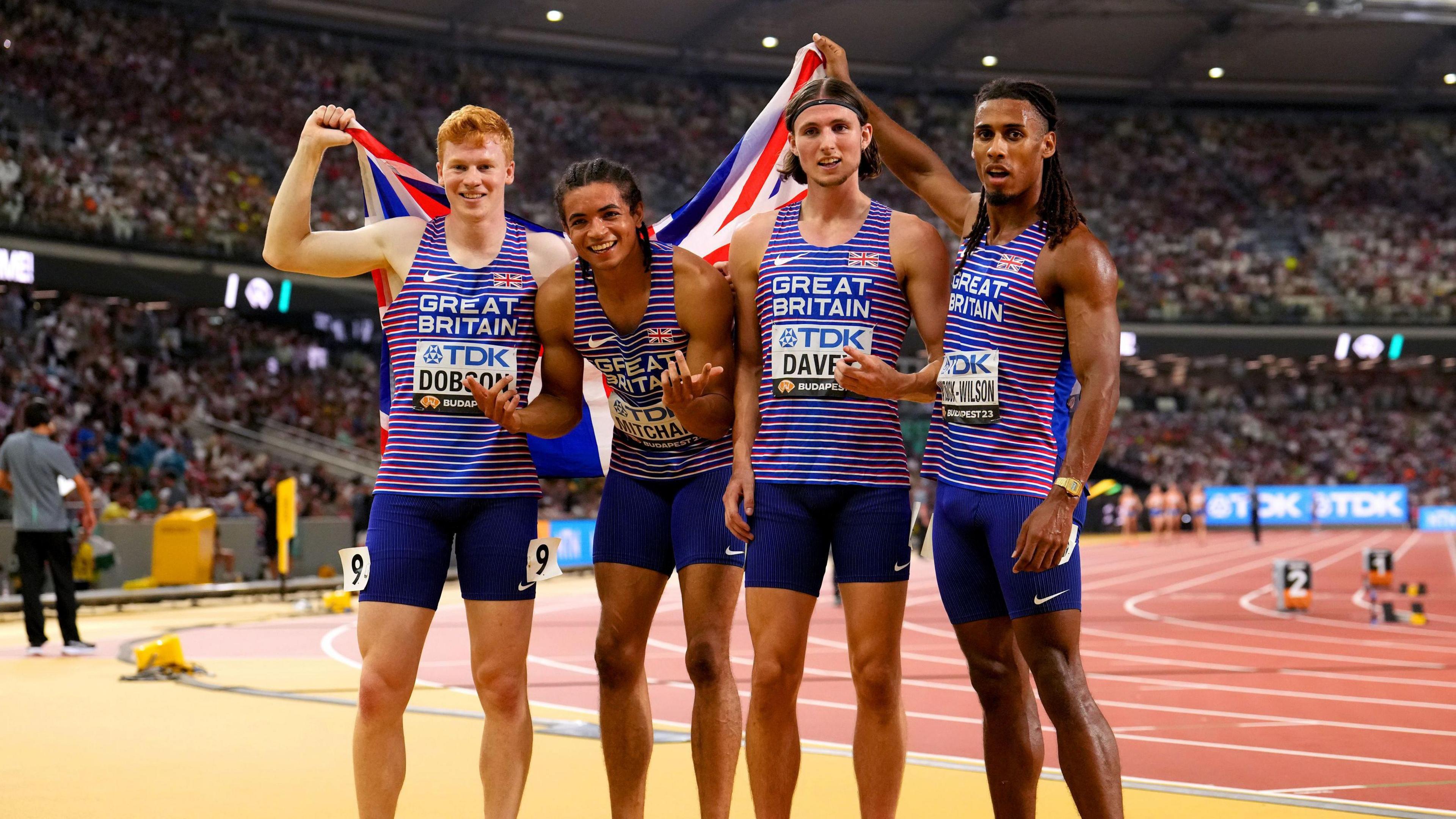 Great Britain's Charlie Dobson, Rio Mitcham, Lewis Davey and Alex Haydock-Wilson pose for a photo on the side of the athletics track after winning bronze at the Paris Olympics.