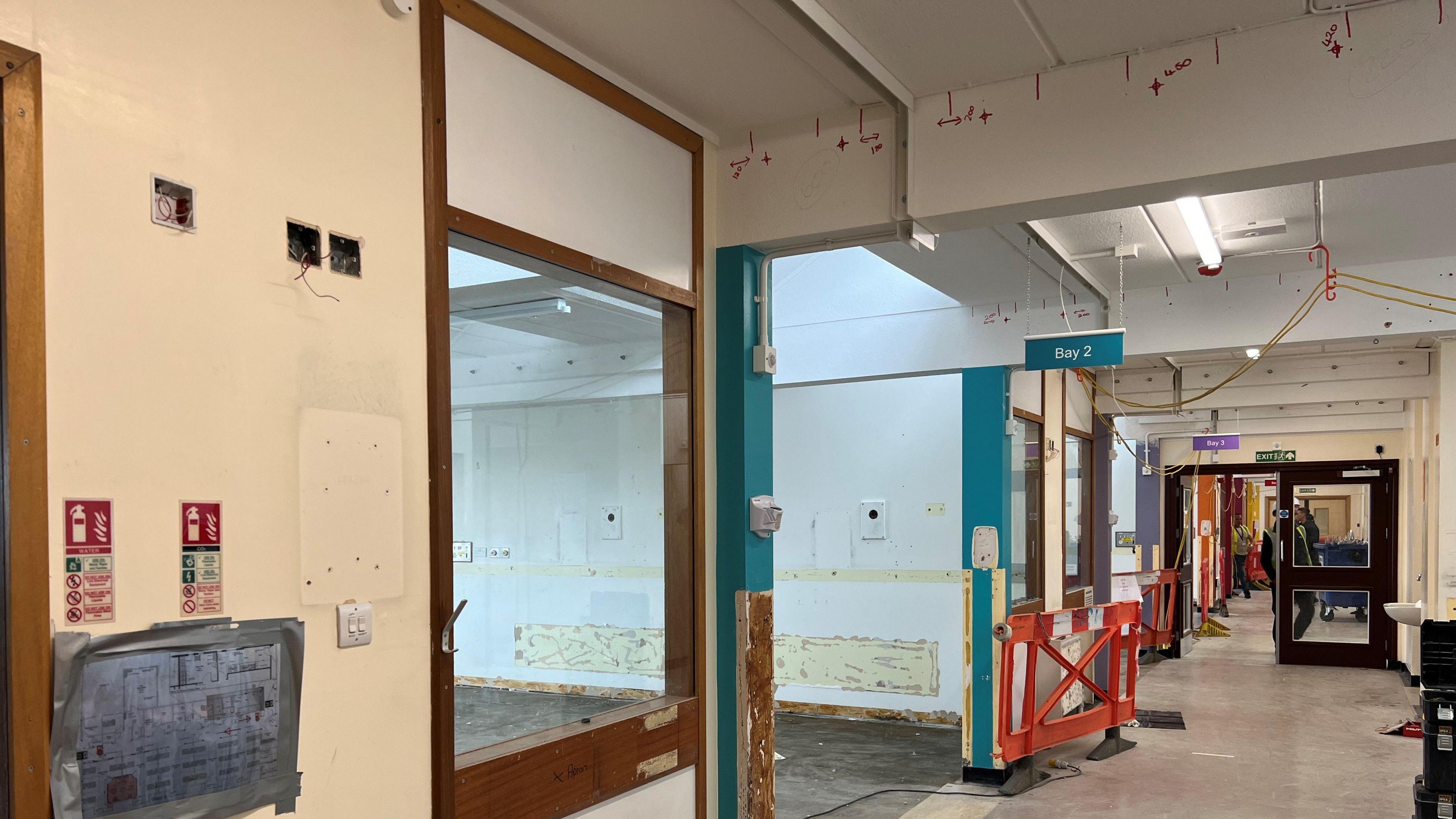 A hospital ward and corridor stripped out for repairs.
