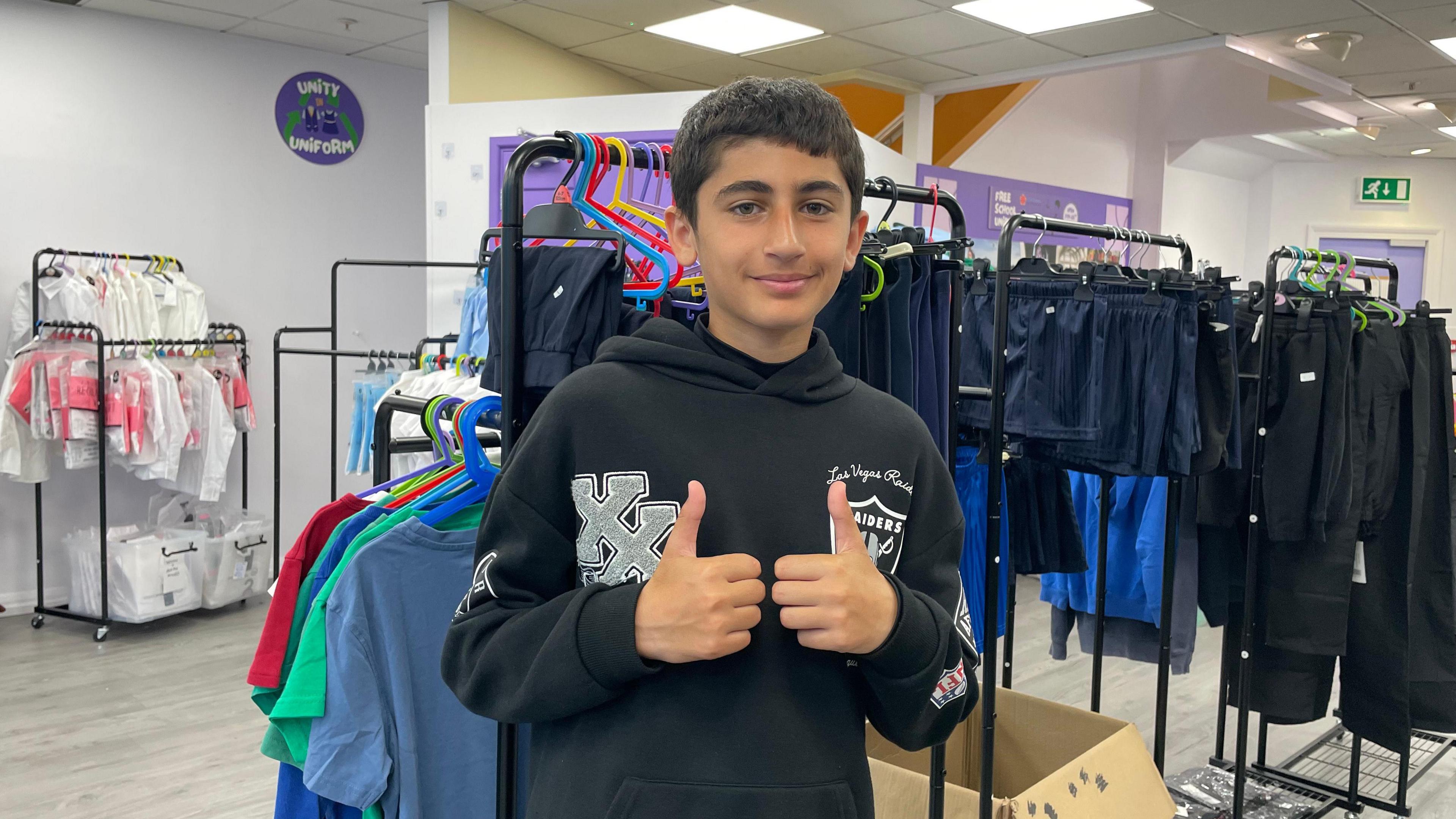 Younis in a black hoodie with his thumbs up