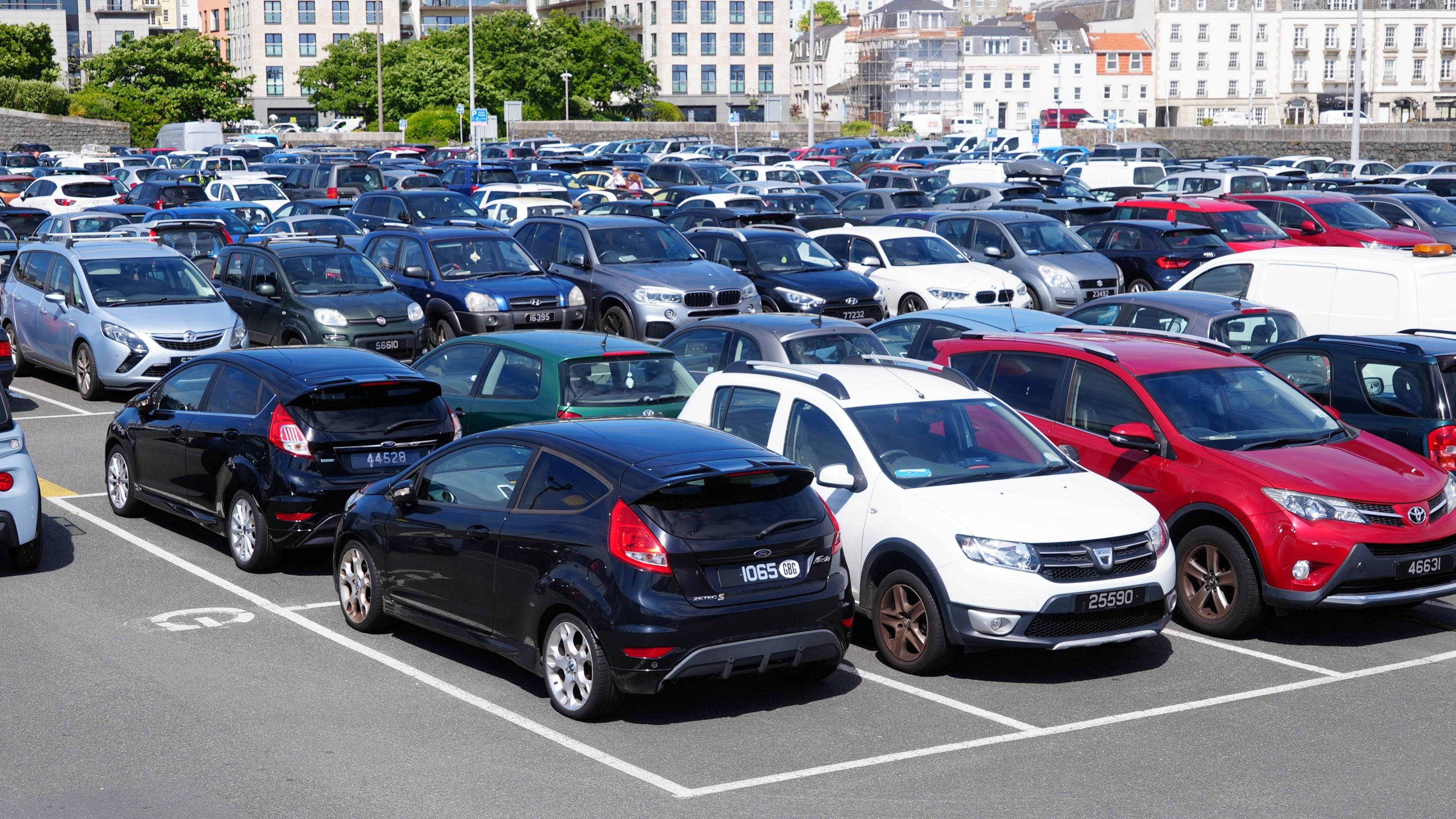 A car park with a number of parked cars. 