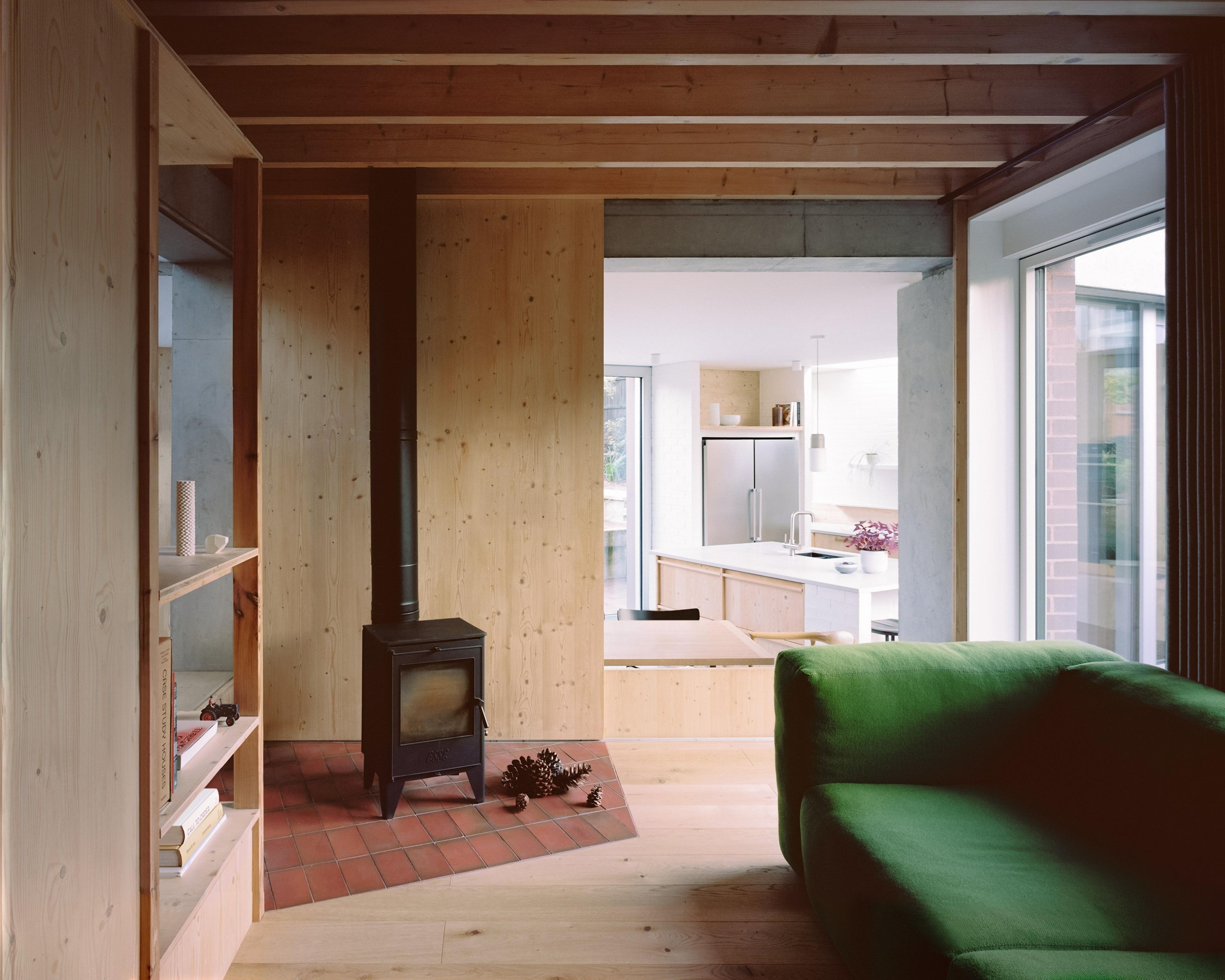 Wooden interior of six columns with fireplace and green sofa