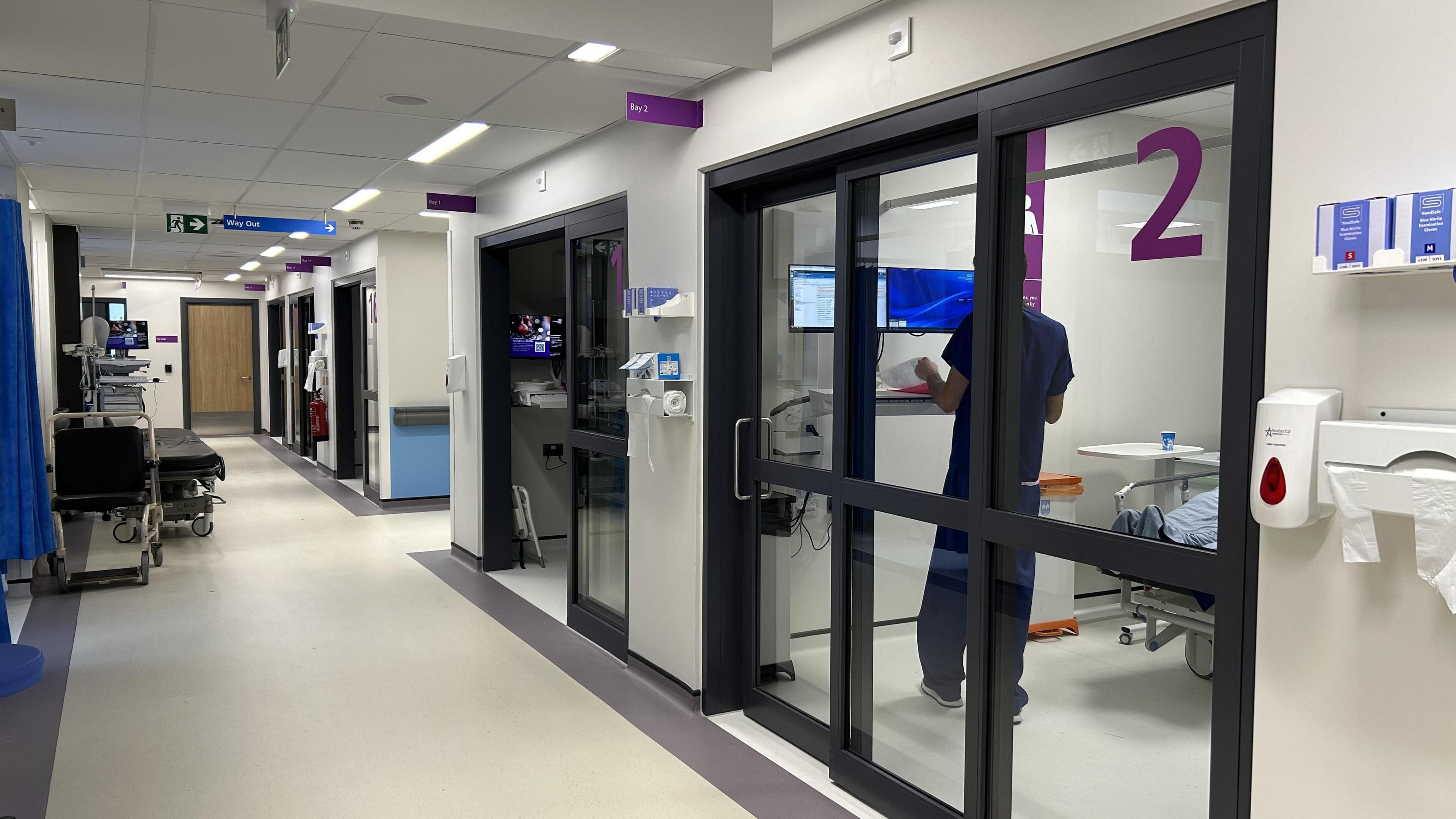 The inside of the emergency department at QA hospital showing glass doors to cubicles.