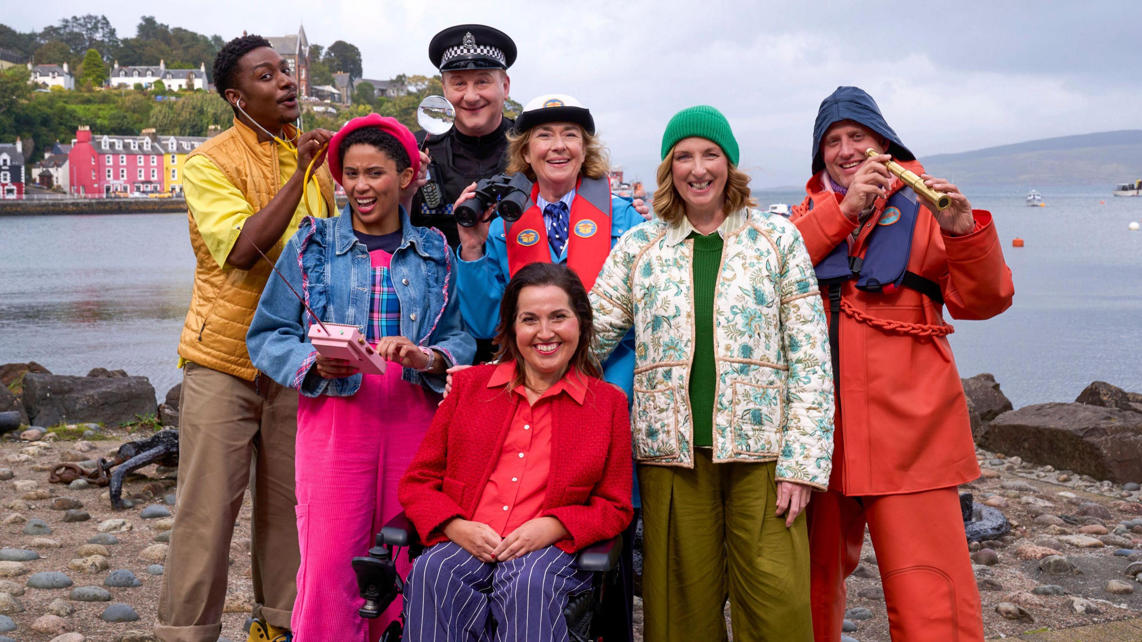 The cast of the Balamory revival stand on the harbour dressed as their characters - Ollie (CARL SPENCER), Ava Potts (DANIELLE JAM), PC Plum (ANDREW AGNEW), Edie McCredie (JULIET CADZOW), Penny Pocket (KIM TSERKEZIE), Miss Hoolie (JULIE WILSON NIMMO), Harbourmaster (WILLIAM ANDREWS)