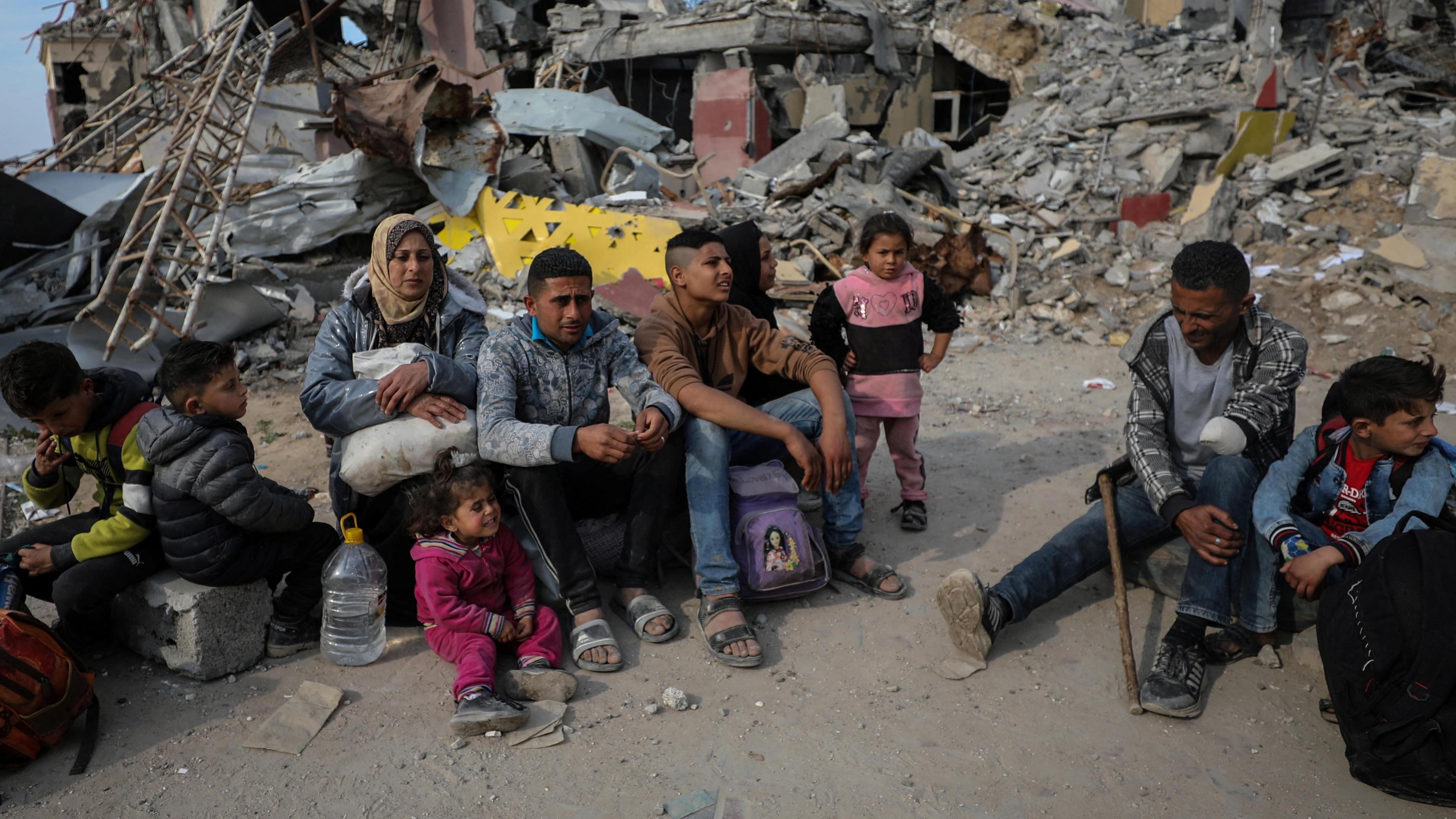 Displaced Palestinians from the Mohammed family sit on the rubble of destroyed buildings in the Gaza Strip (28 January 2025)