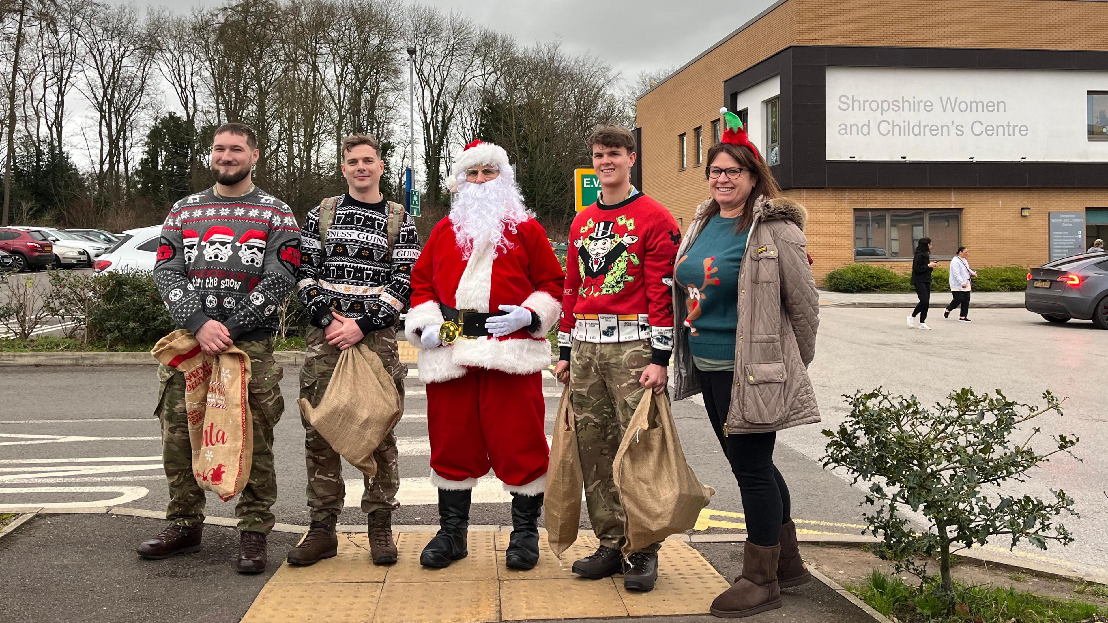 Father Christmas stood in front of the Women and Children's Centre at the Princess Royal Hospital. Stood next to him are his 'elves', who are wearing Christmas jumpers and army fatigues.