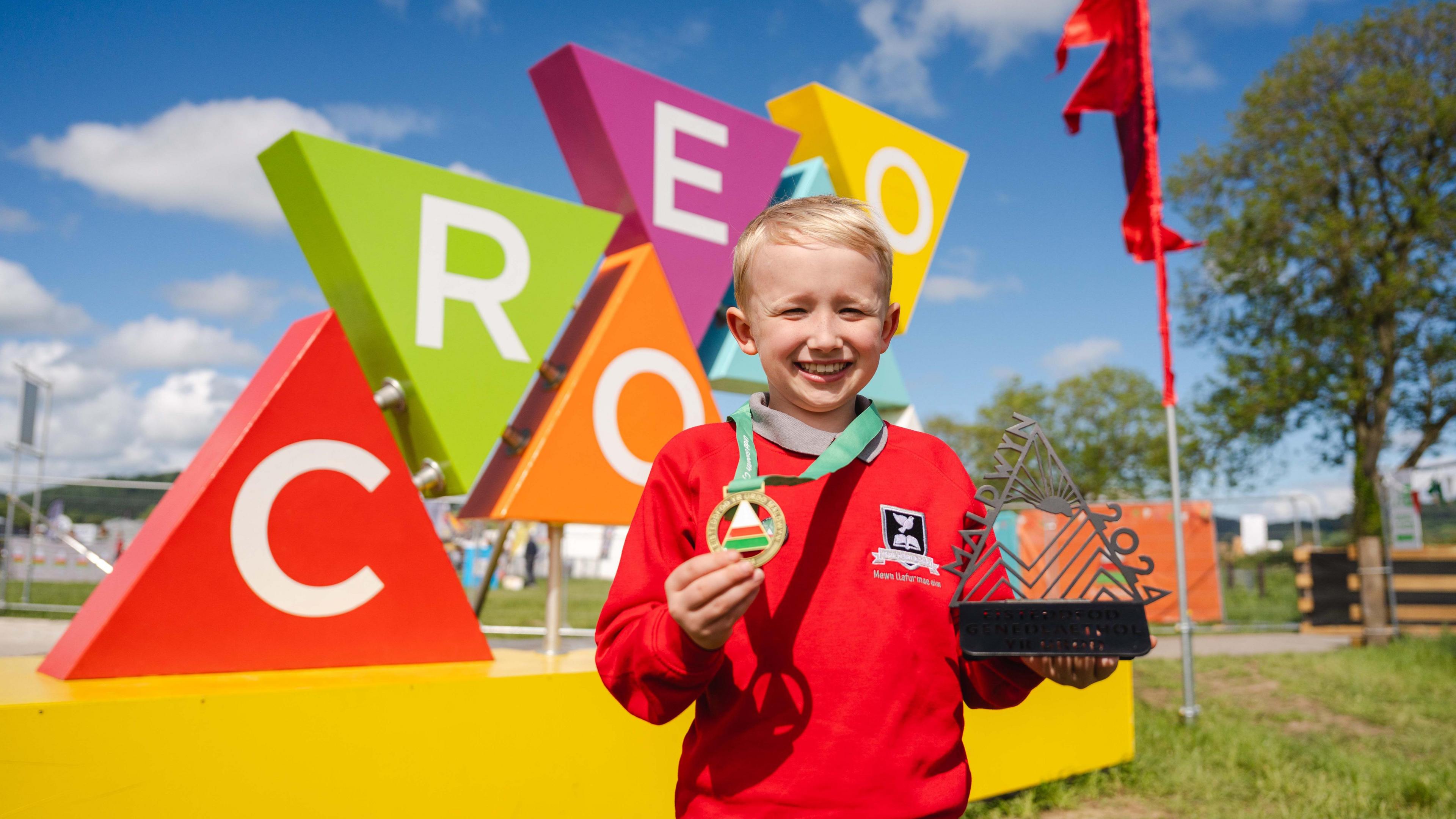 Young boy shows his medal from winning a competition at the festival.