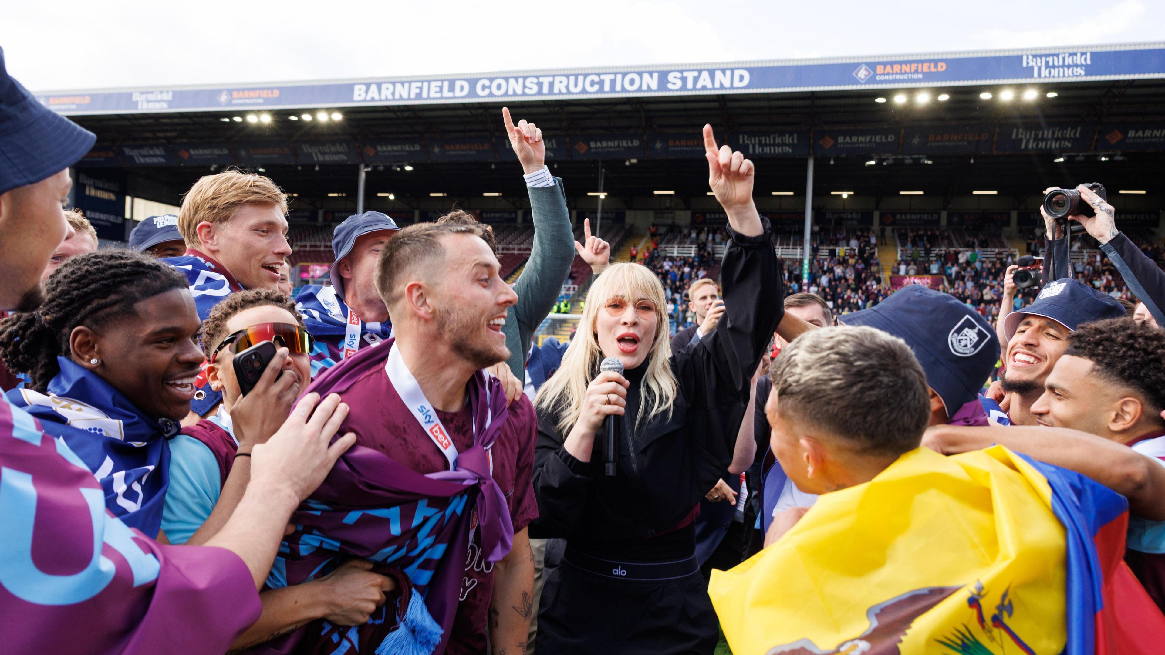 Natasha Bedingfield sings on the pitch after Burnley secure promotion.