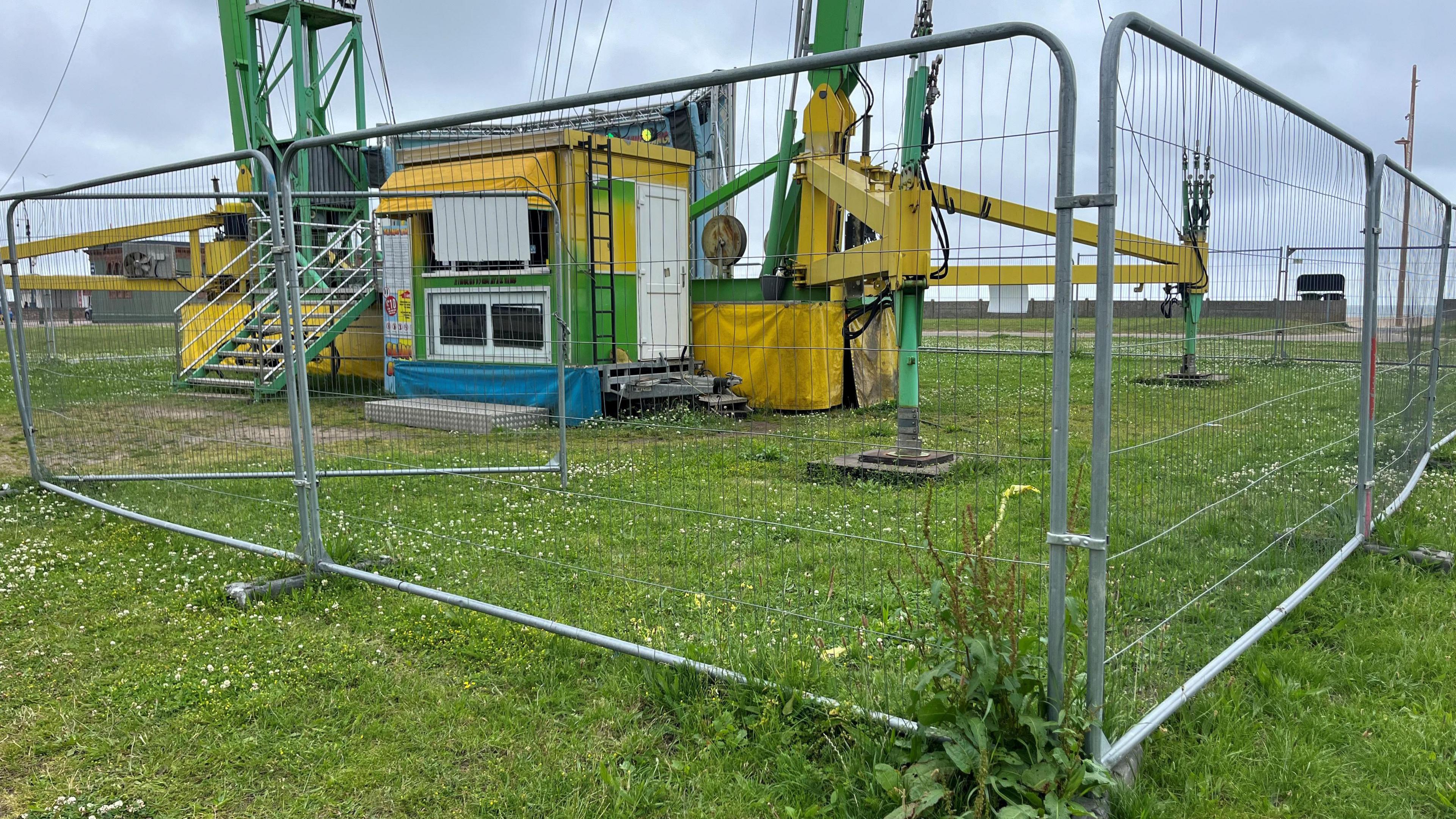 Silver fencing in front of the base of the Slingshot ride