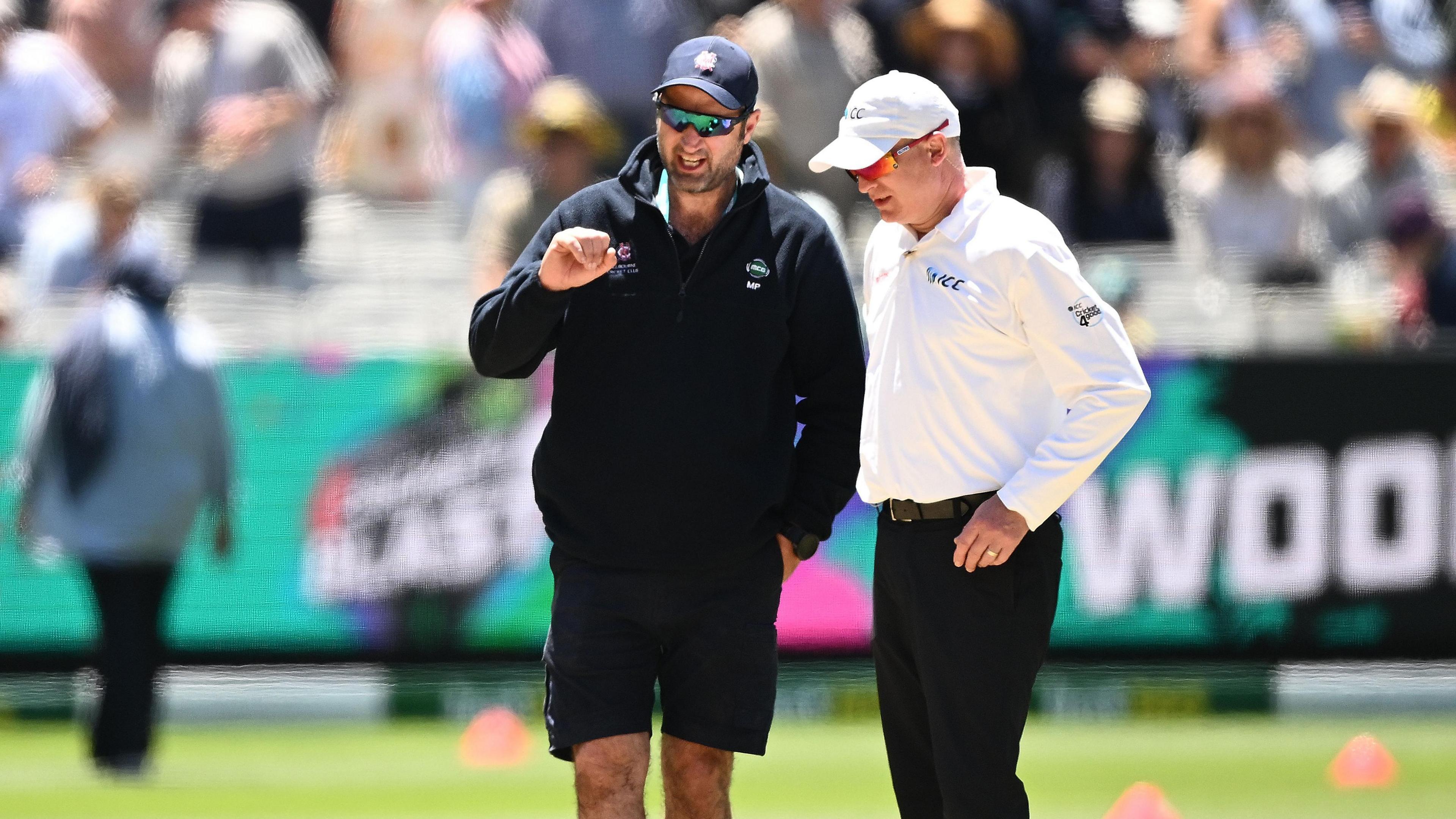 Matt Page (izquierda), encargado del terreno de juego del Melbourne Cricket Ground, inspecciona el campo durante la pausa del almuerzo del segundo día.