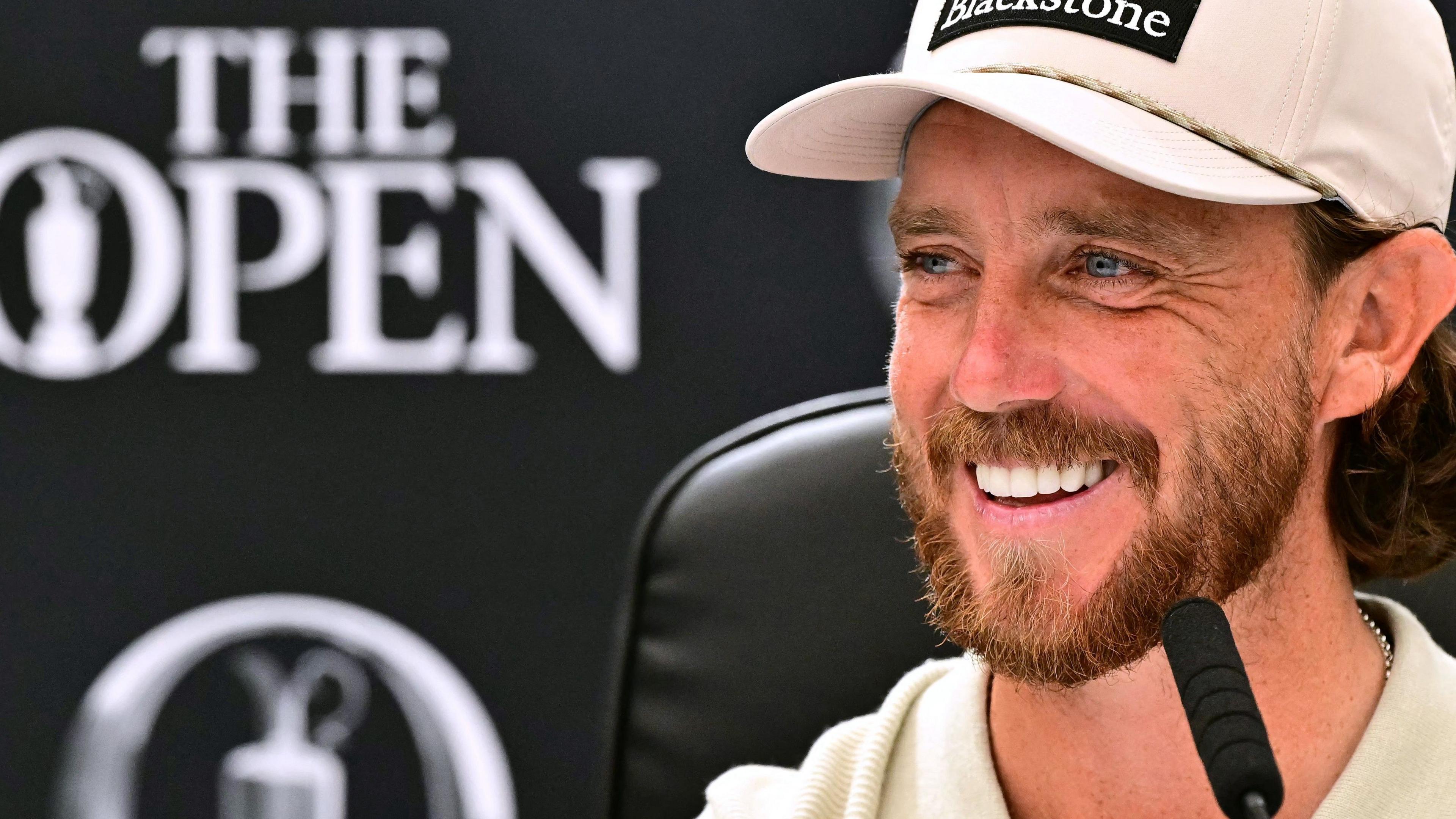 Tommy Fleetwood smiling while speaking at a news conference before the 154th Open Championship at Royal Birkdale