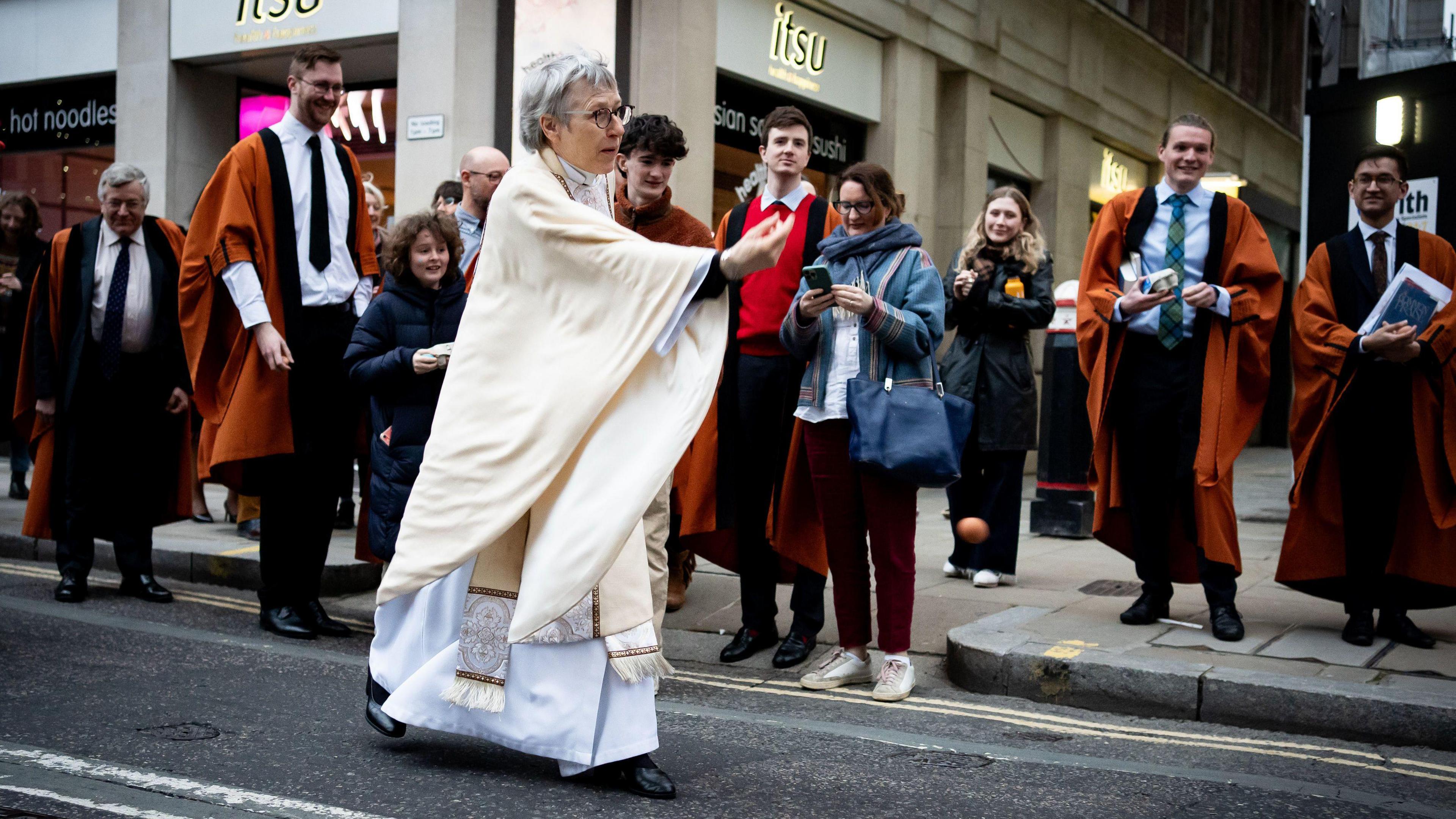 Clergy member rolls egg