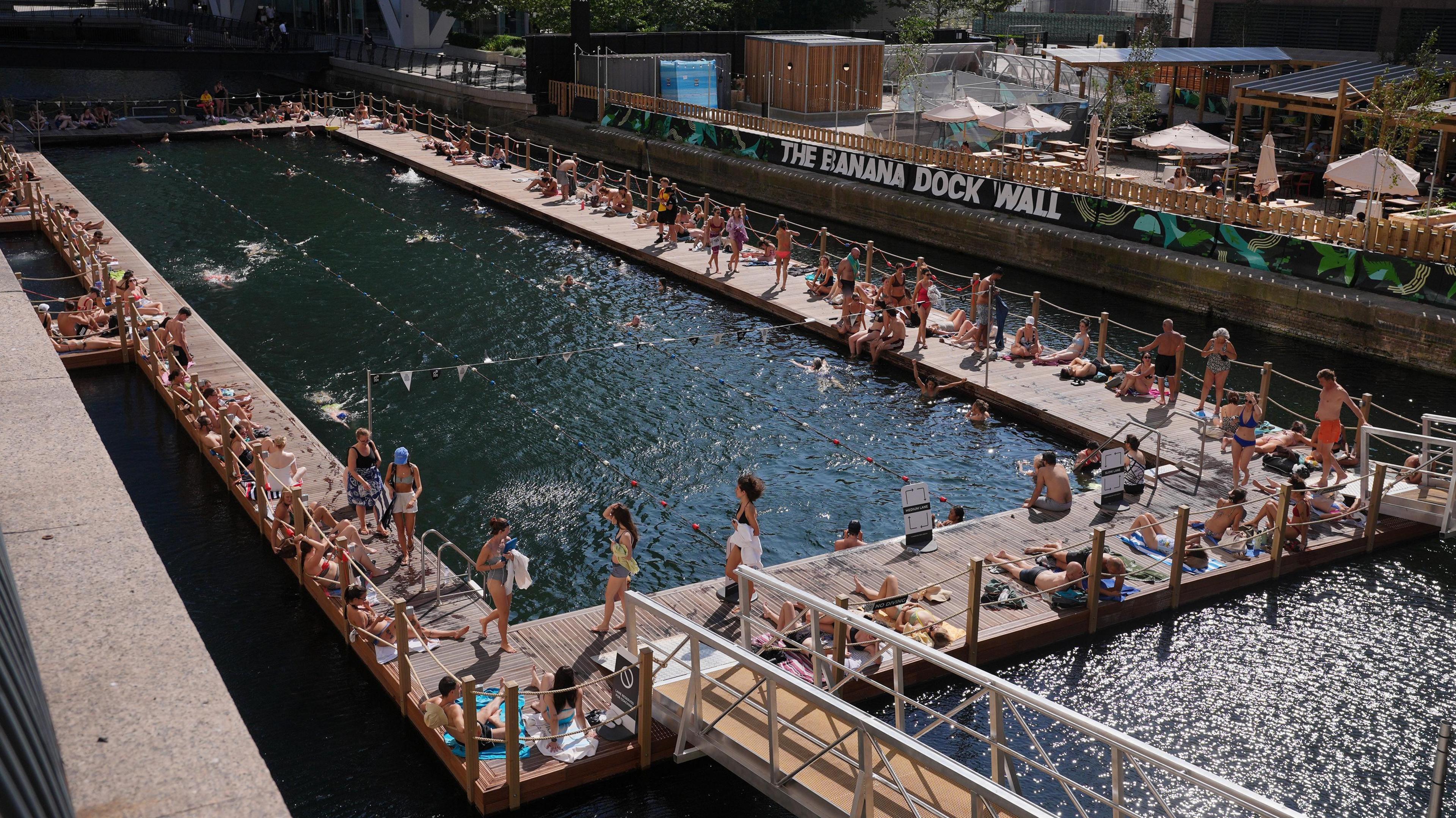 People relaxing at the 50m fresh-water pool Sea Lanes Canary Wharf, in London