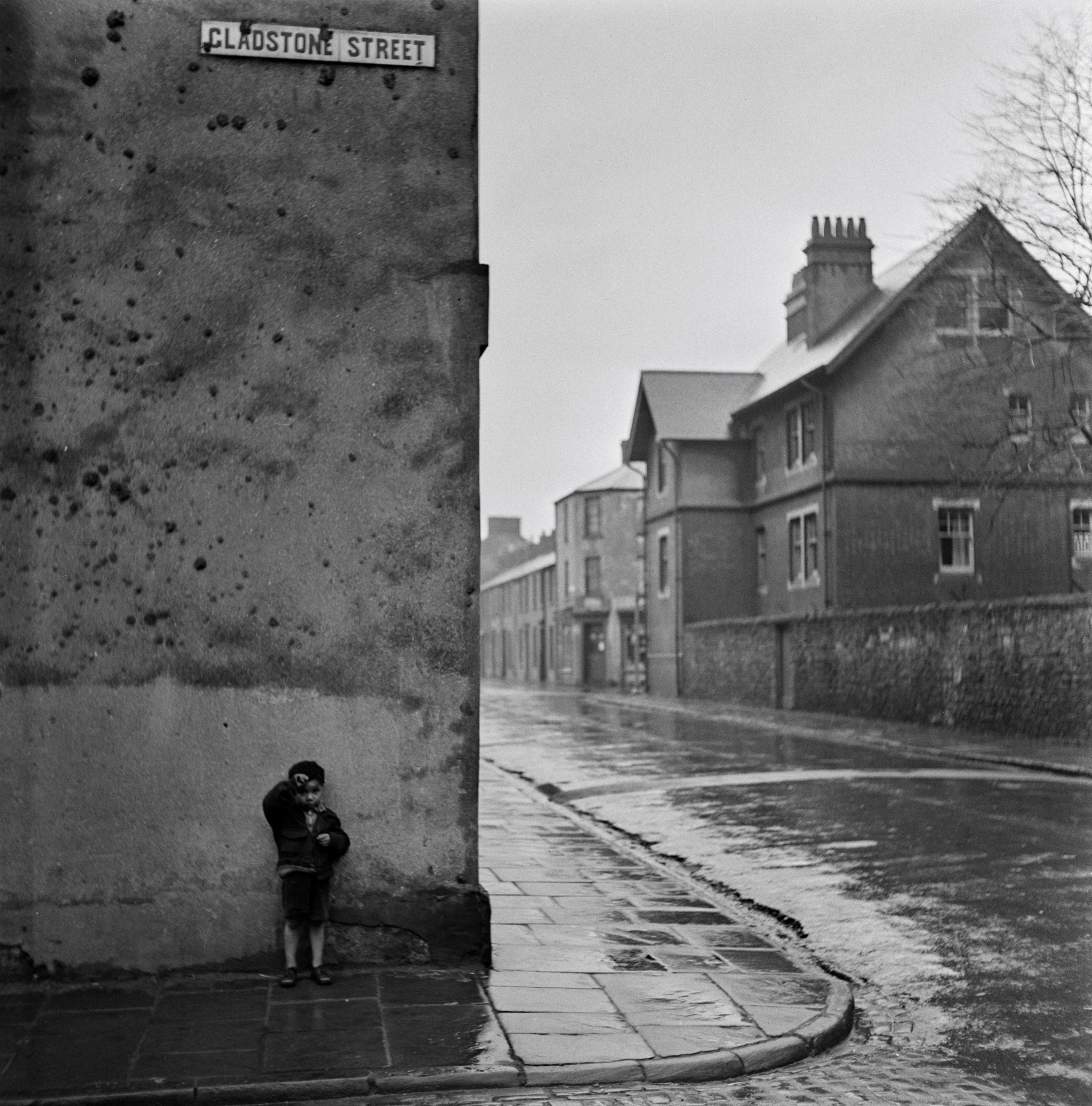 A small boy standing on the corner of Gladstone Street
