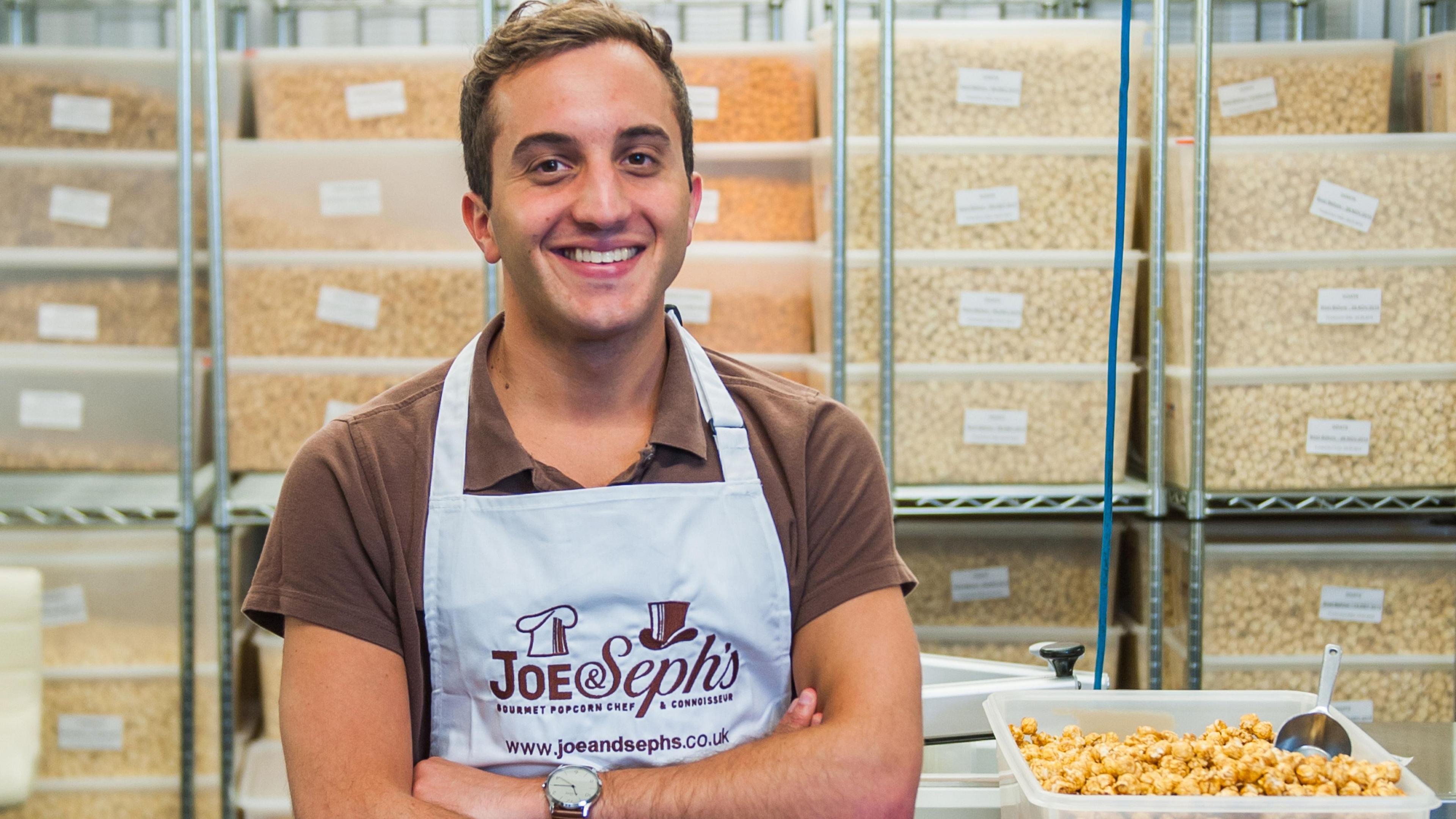 Adam Sopher, co-founder and chief executive of Joe & Seph’s popcorn, sitting in front of a selection of tubs of popcorn