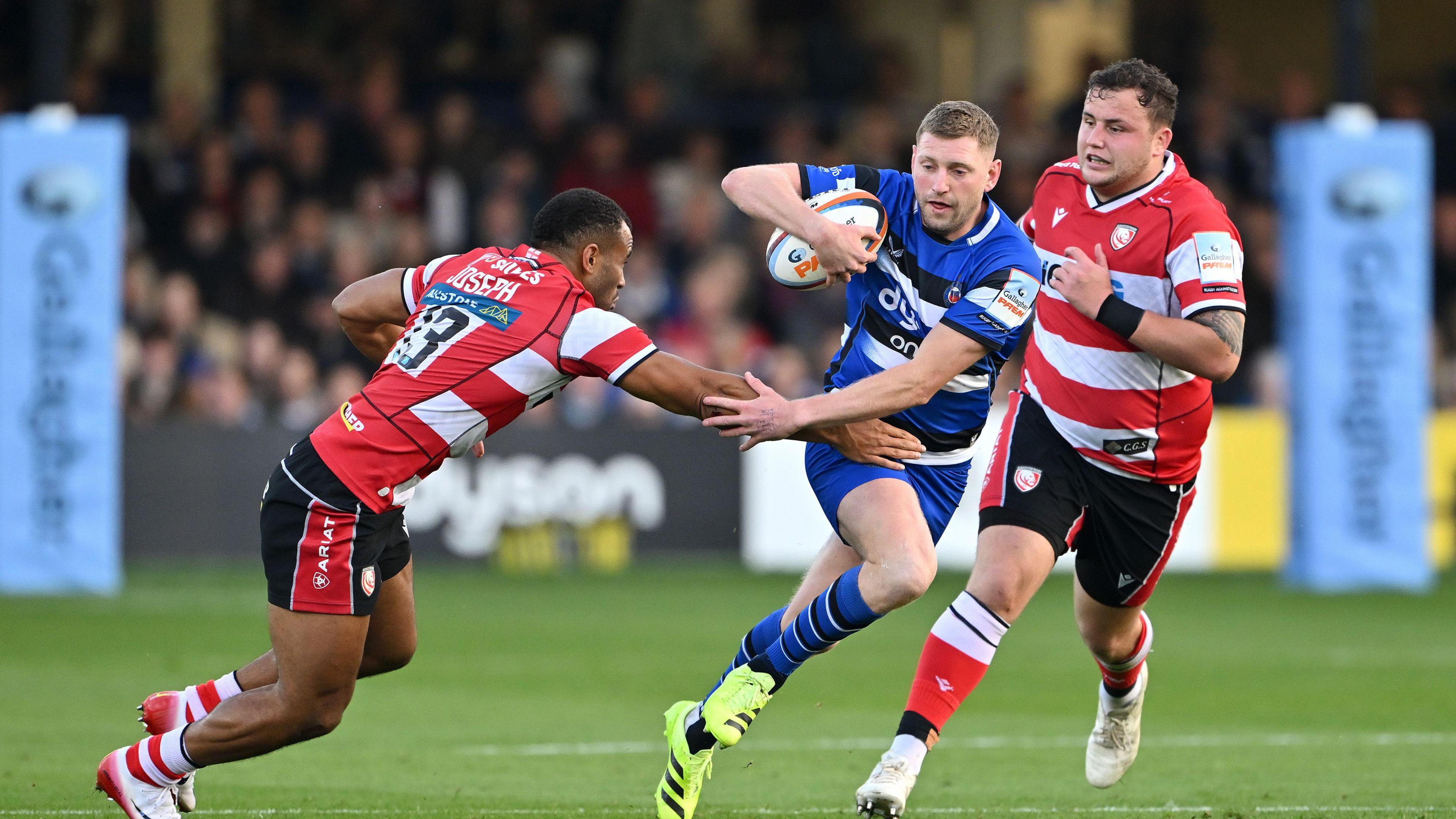 Finn Russell runs between two Gloucester defenders 