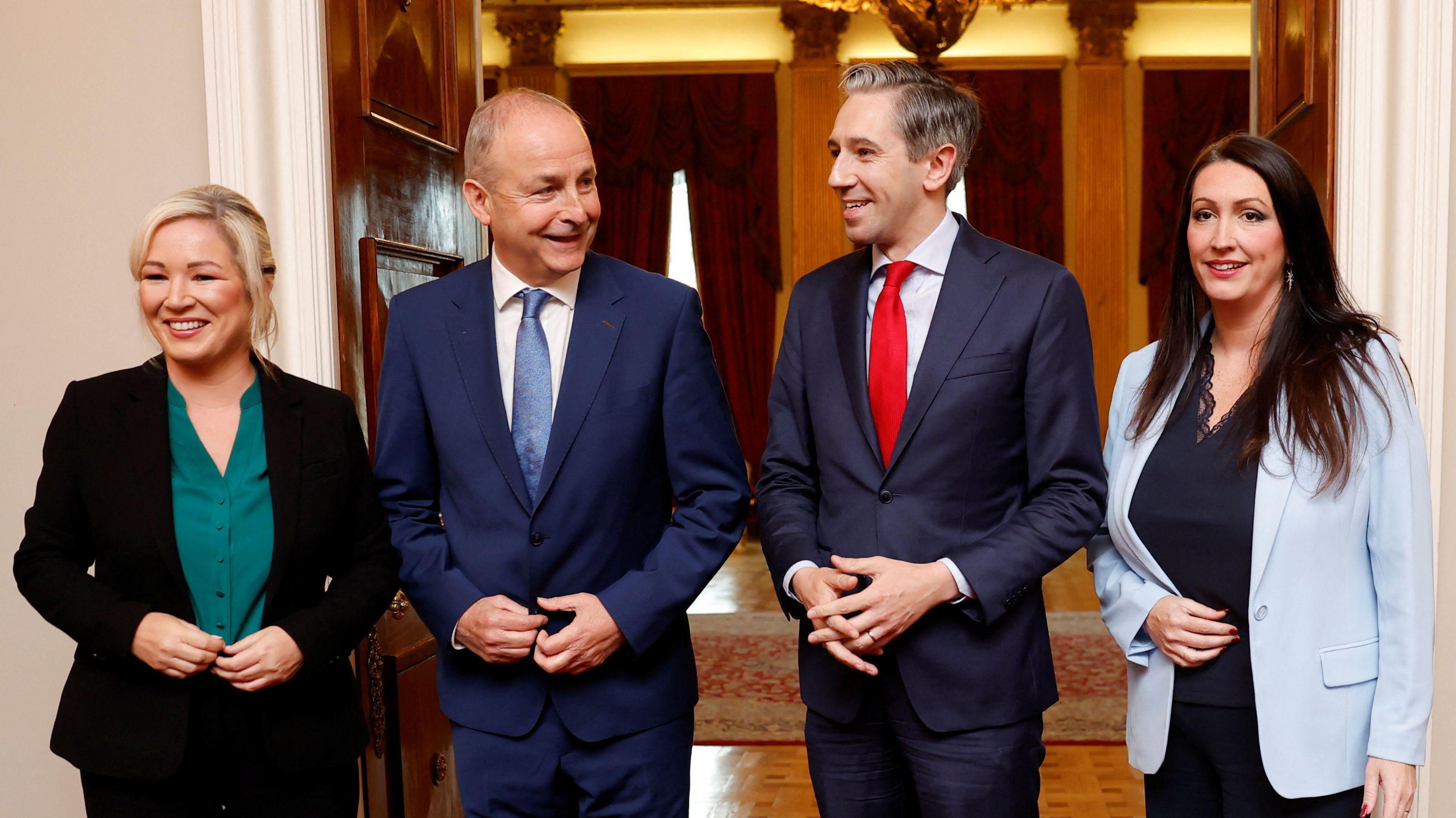 Left to right are Michelle O'Neill in a black suit and green blouse, Micheál Martin in a blue suit, white shirt and blue tie, Simon Harris in a blue suit, blue shirt and red tie and Emma Little-Pengelly in a black top, black trousers and sky blue blazer