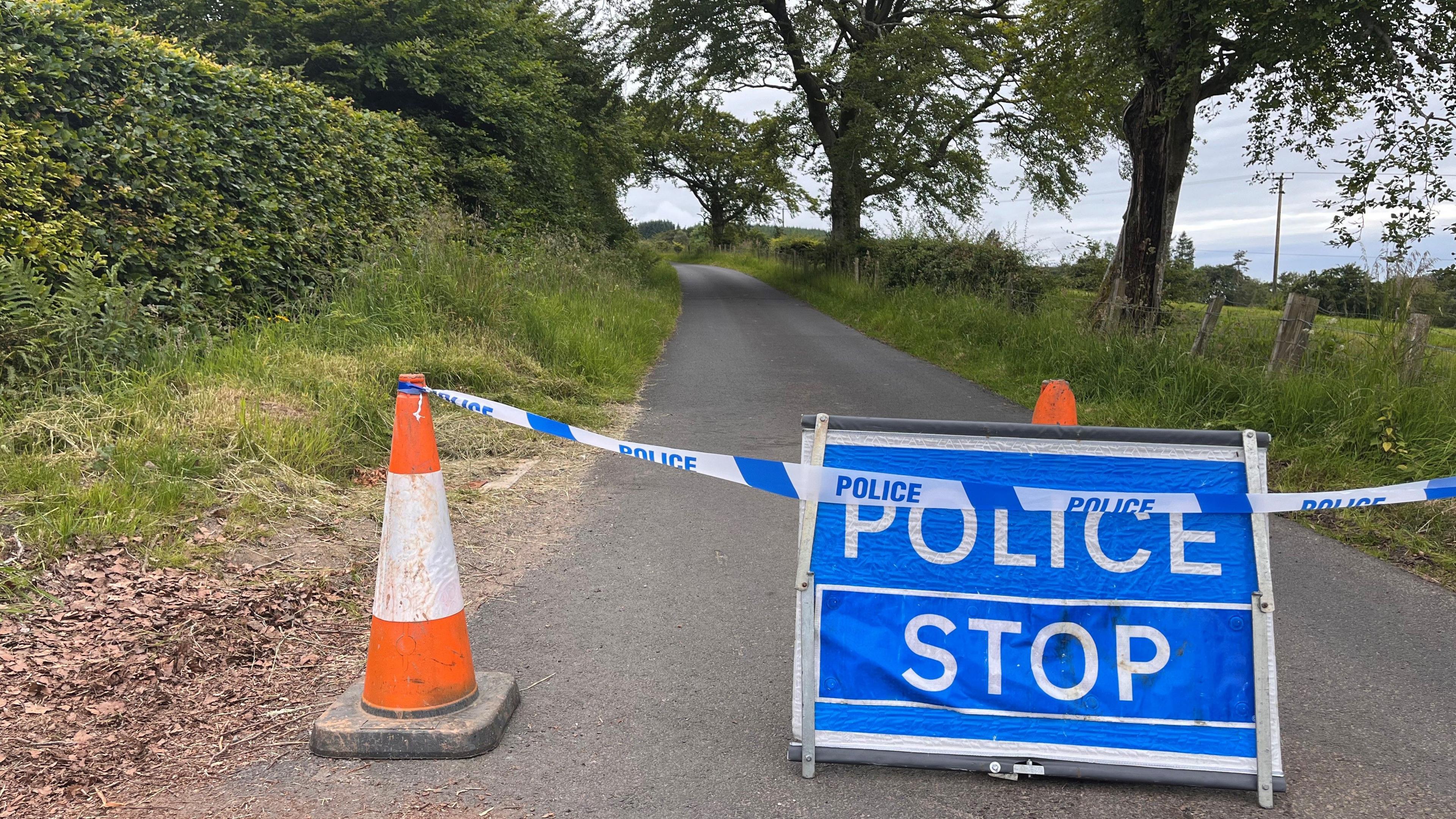 A police sign on a single-track country road