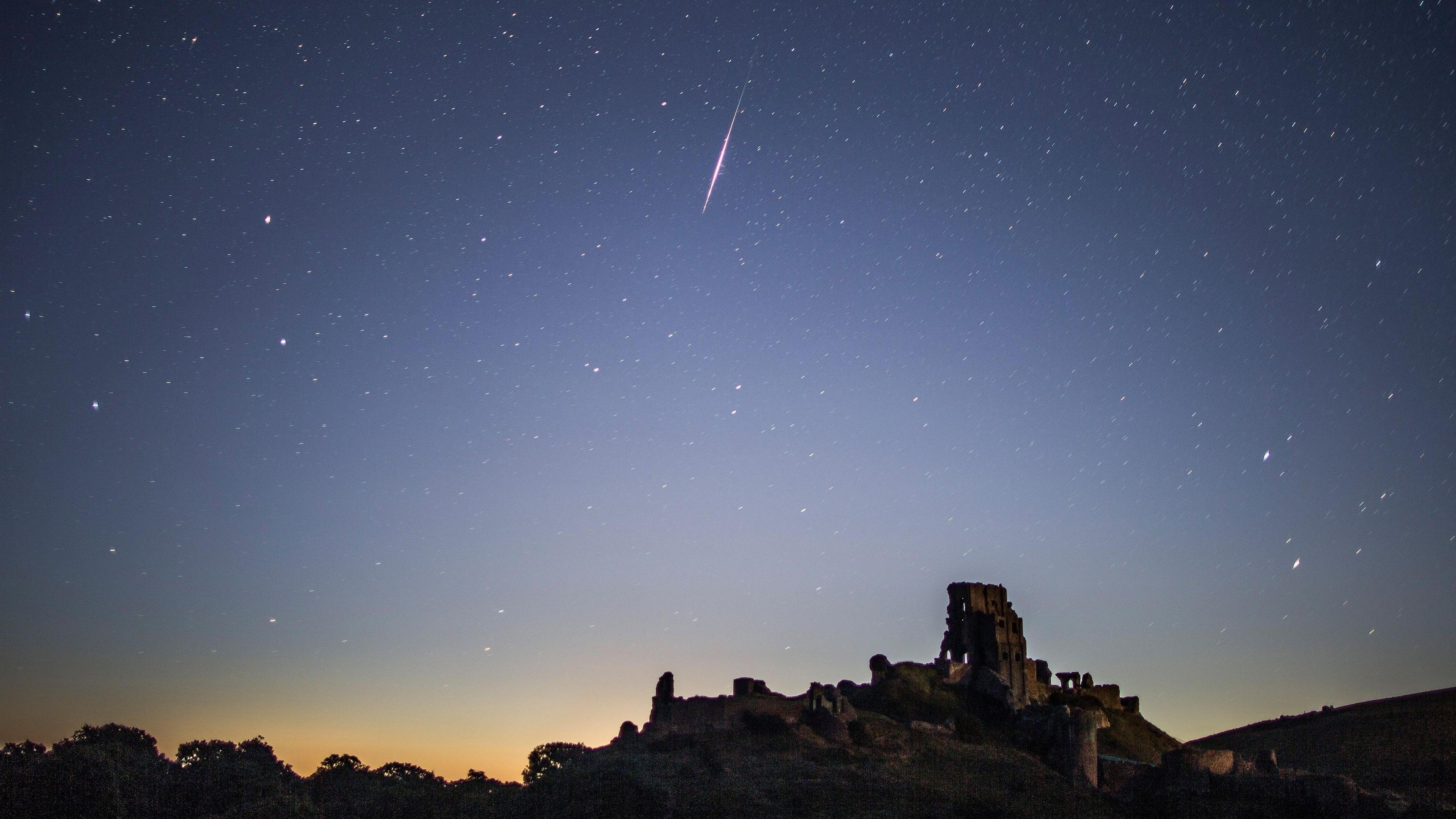 A Perseid Meteor flashes across the night sky above Corfe Castle