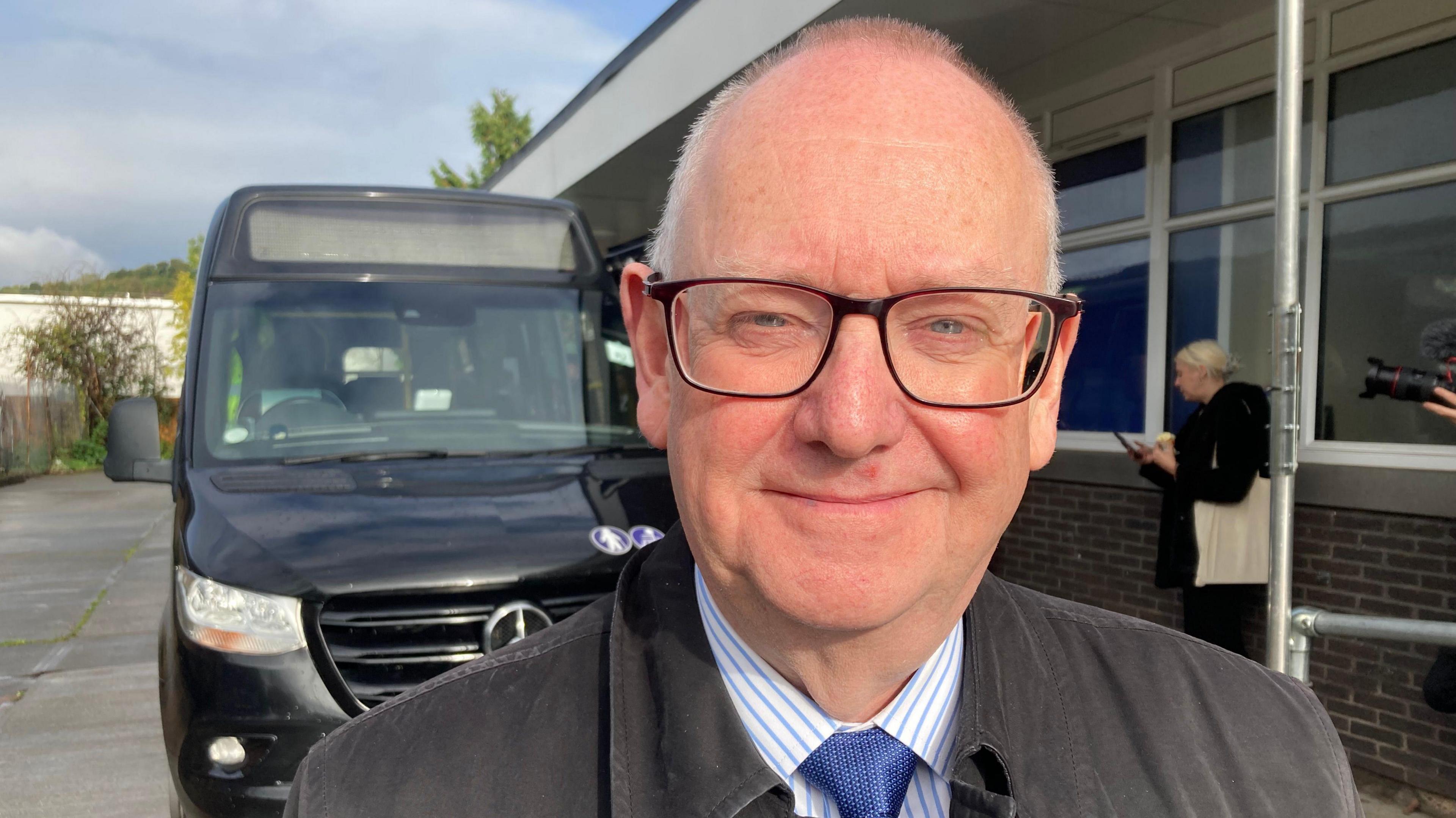 Councillor Philip Robinson with bus behind him