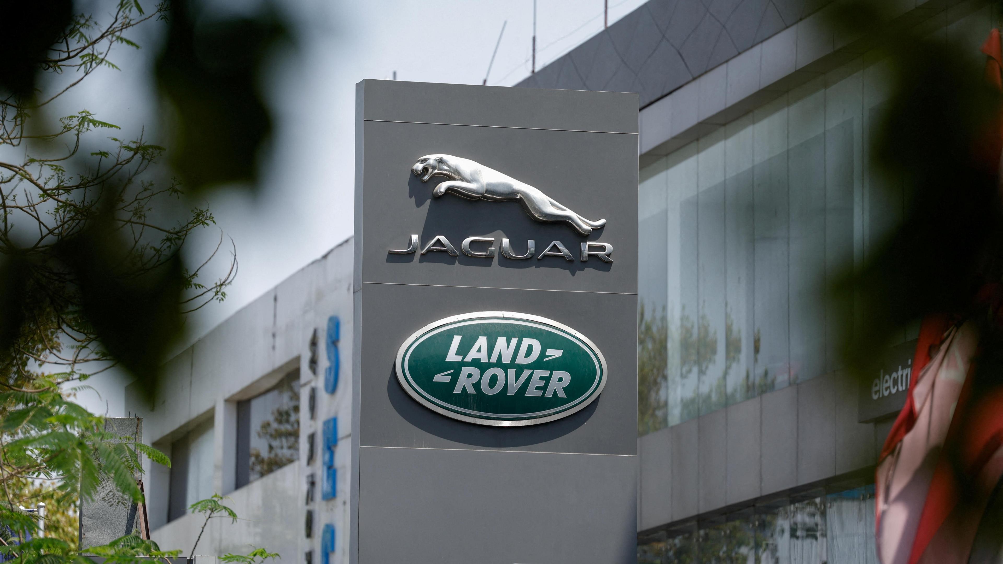 The silver leaping Jaguar emblem is on a grey pillar sign outside one of its factories, with the Land Rover badge below.