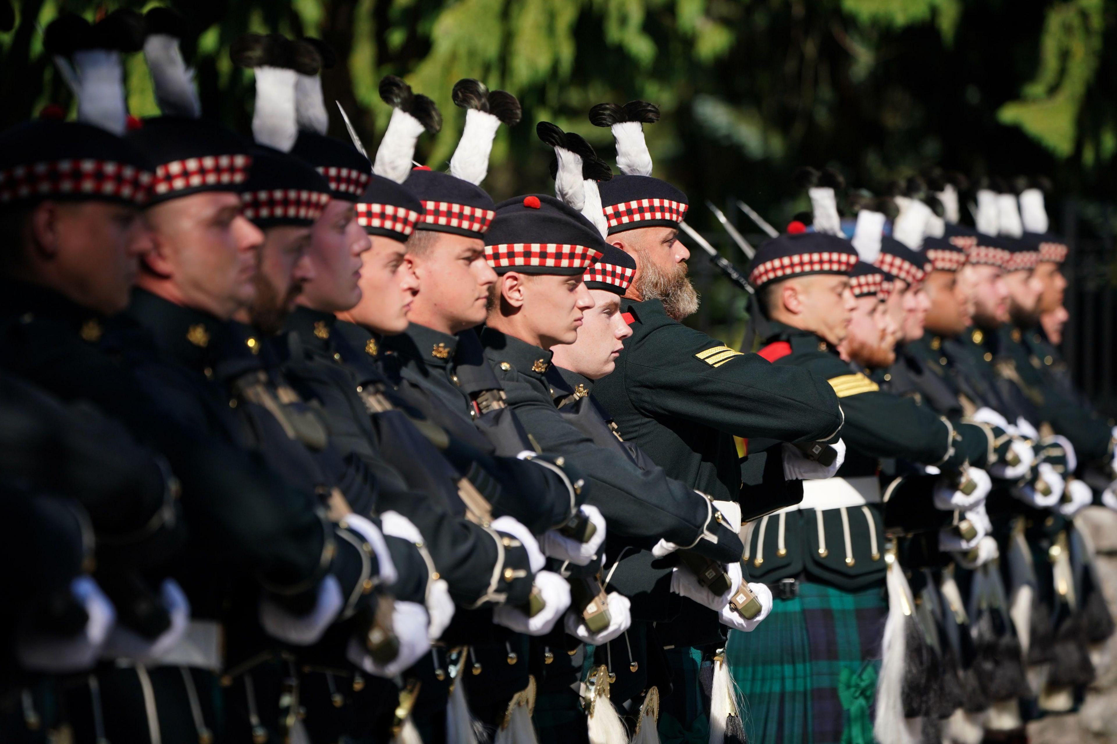 Members of Balaklava Company, 5th Battalion, The Royal Regiment of Scotland, stand in line at the gates of Balmoral