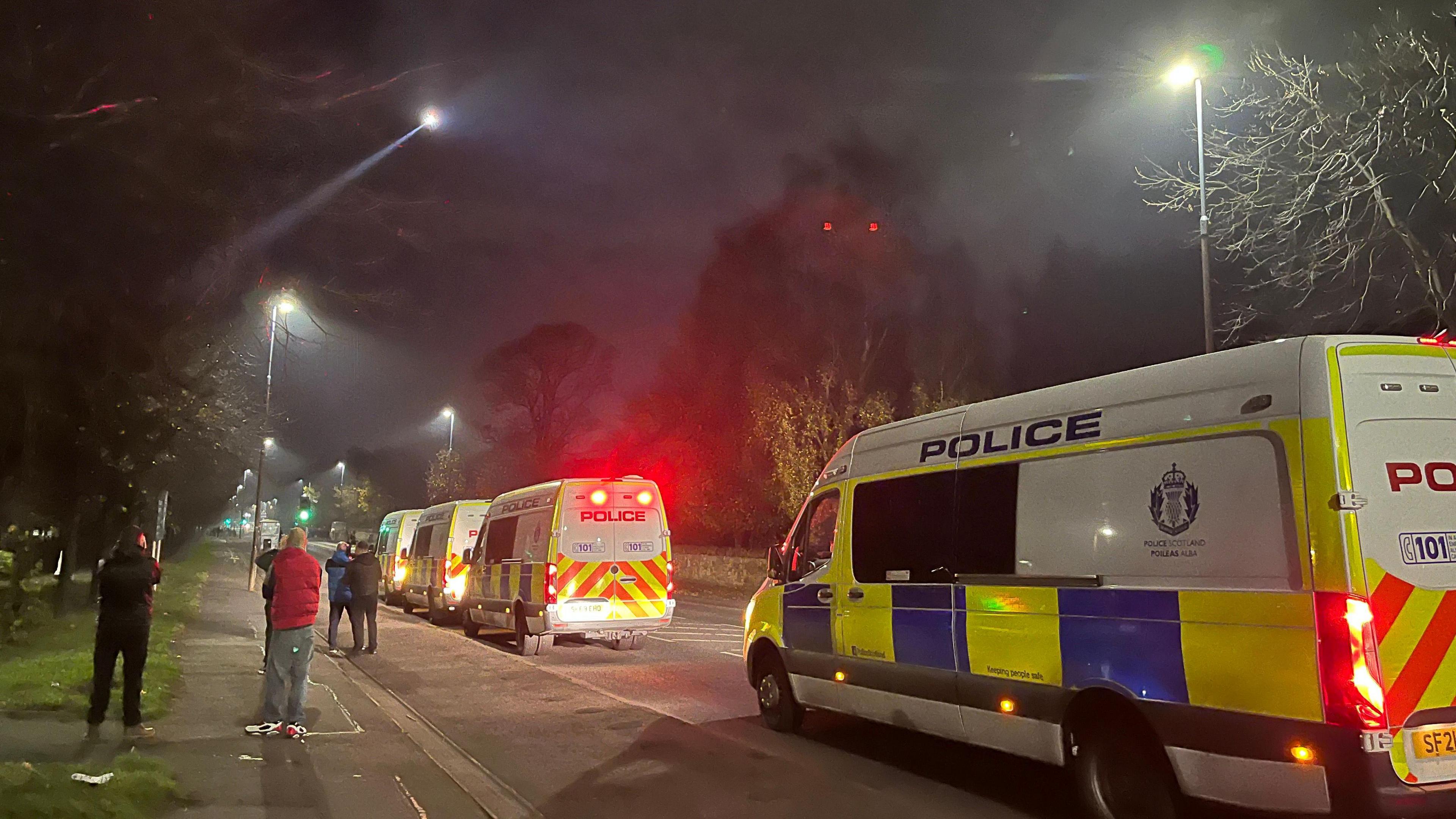 A police helicopter flies overhead as police roadblocks are set up