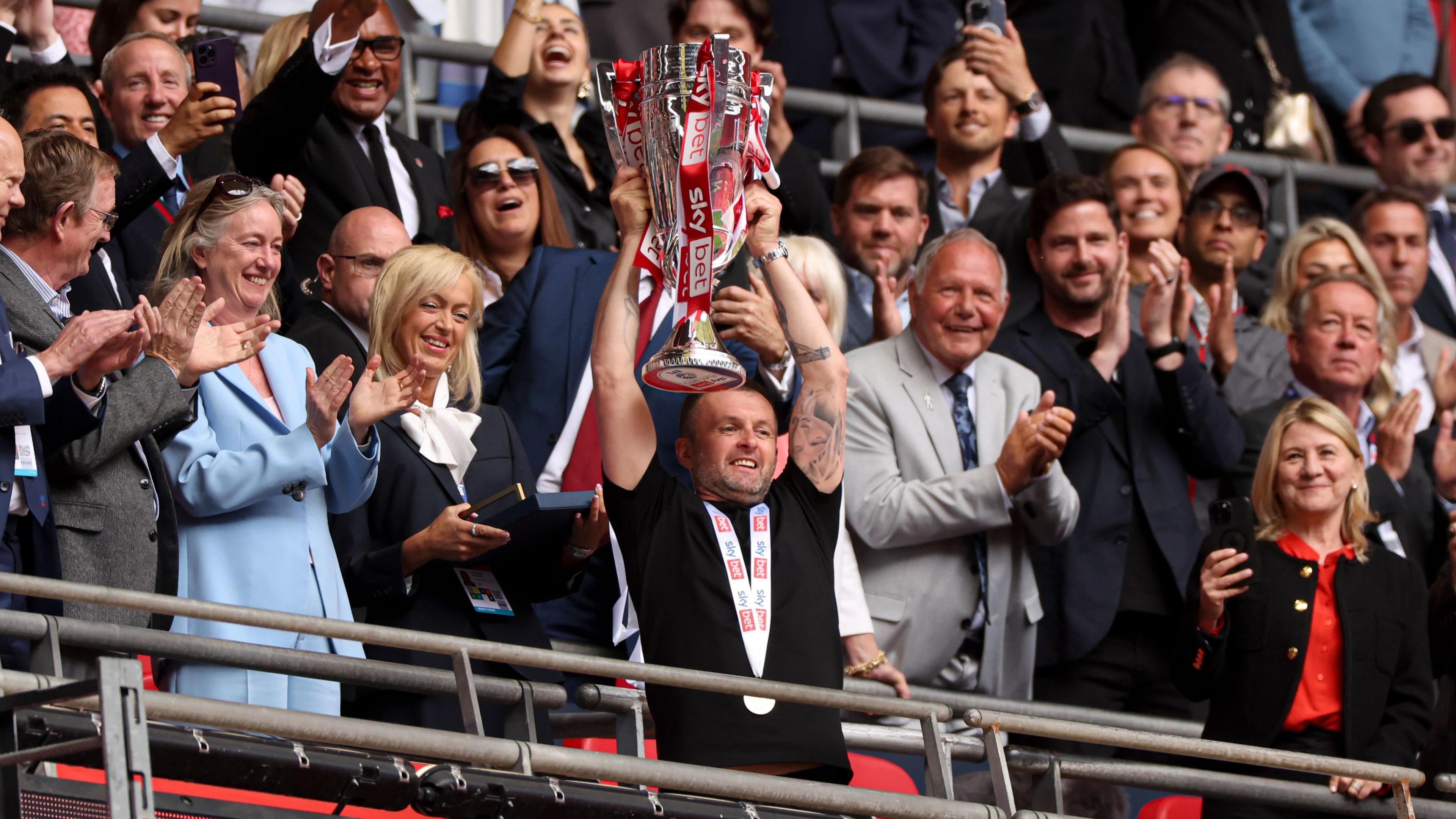 Nathan Jones holds aloft the League One play-off trophy