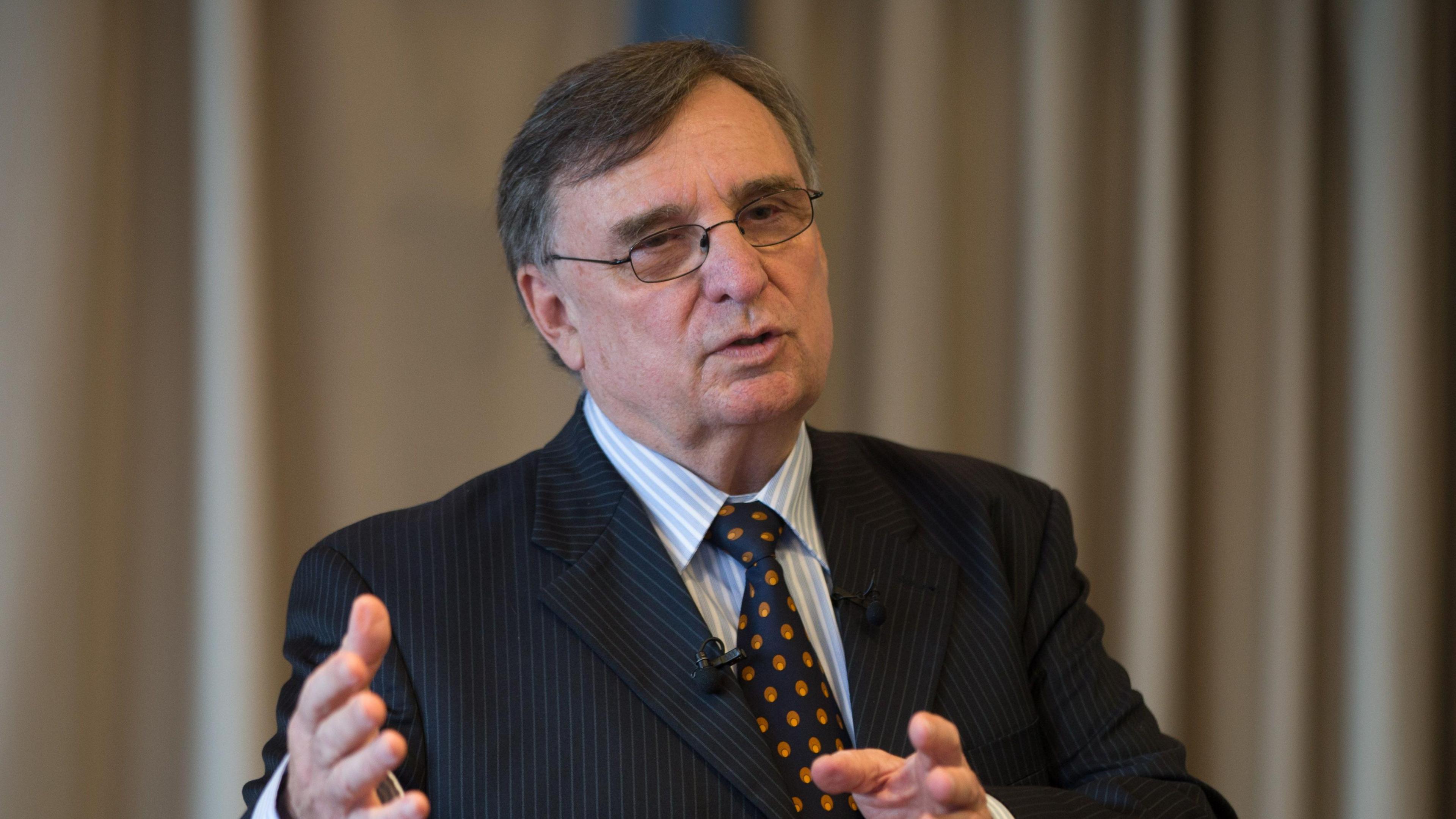 David Moffett wears a dark suit with blue and red tie