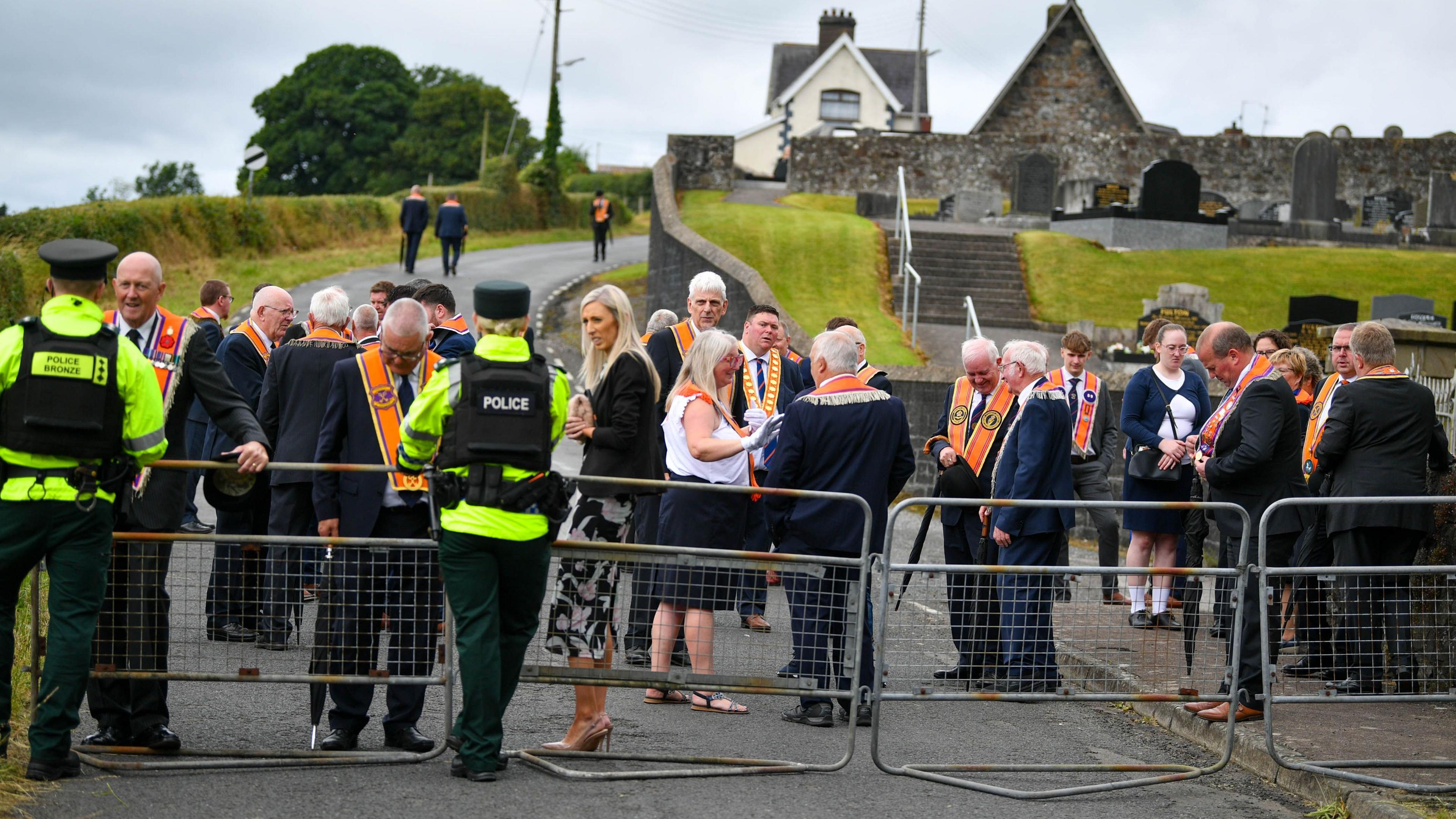 A group of Orange Order members and DUP's Carla Lockhart being blocked by police from walking down a road. 