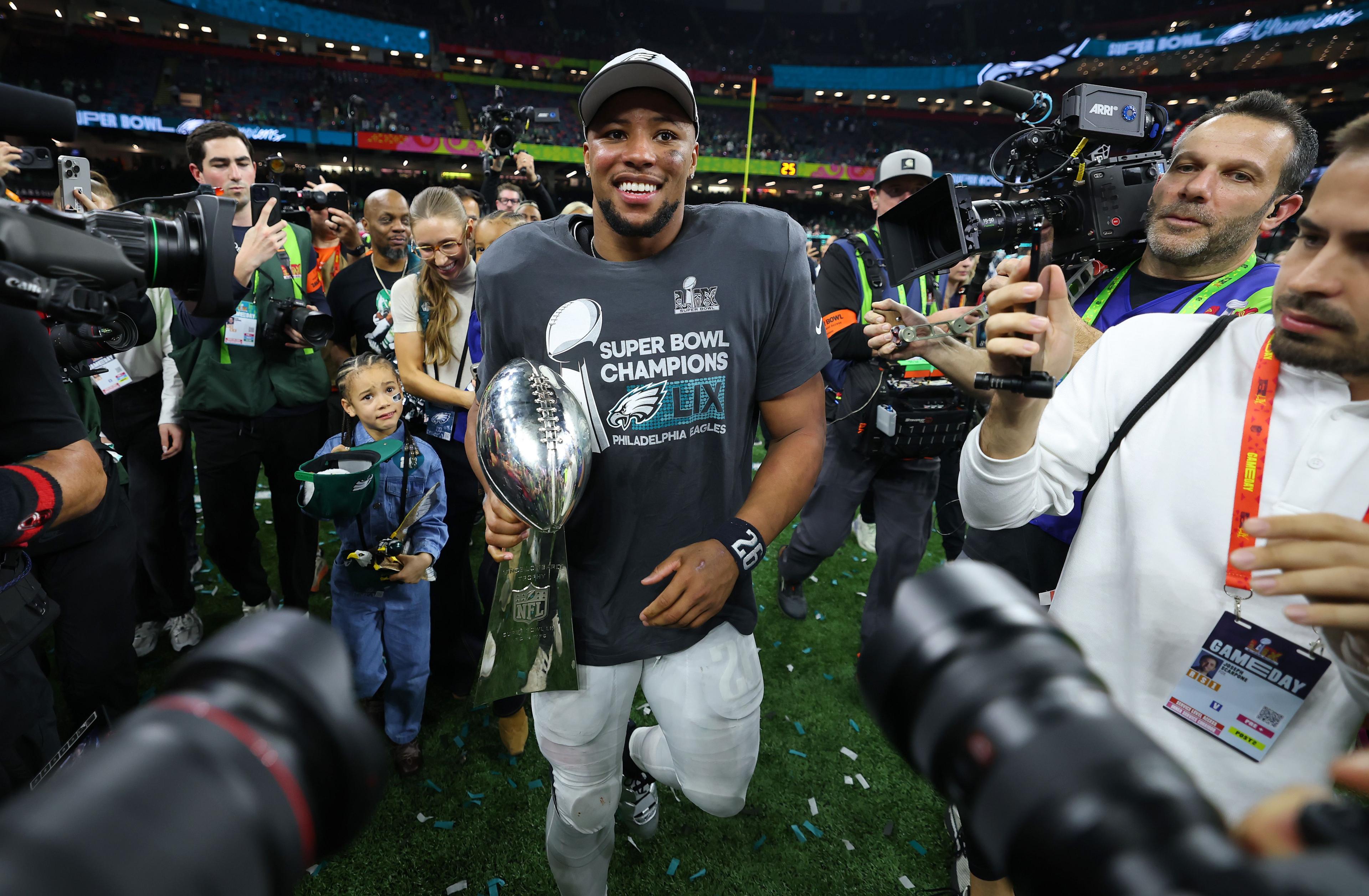 Saquon Barkley of the Philadelphia Eagles celebrates with the Vince Lombardi Trophy after beating the Kansas City Chiefs 40-22 to win Super Bowl