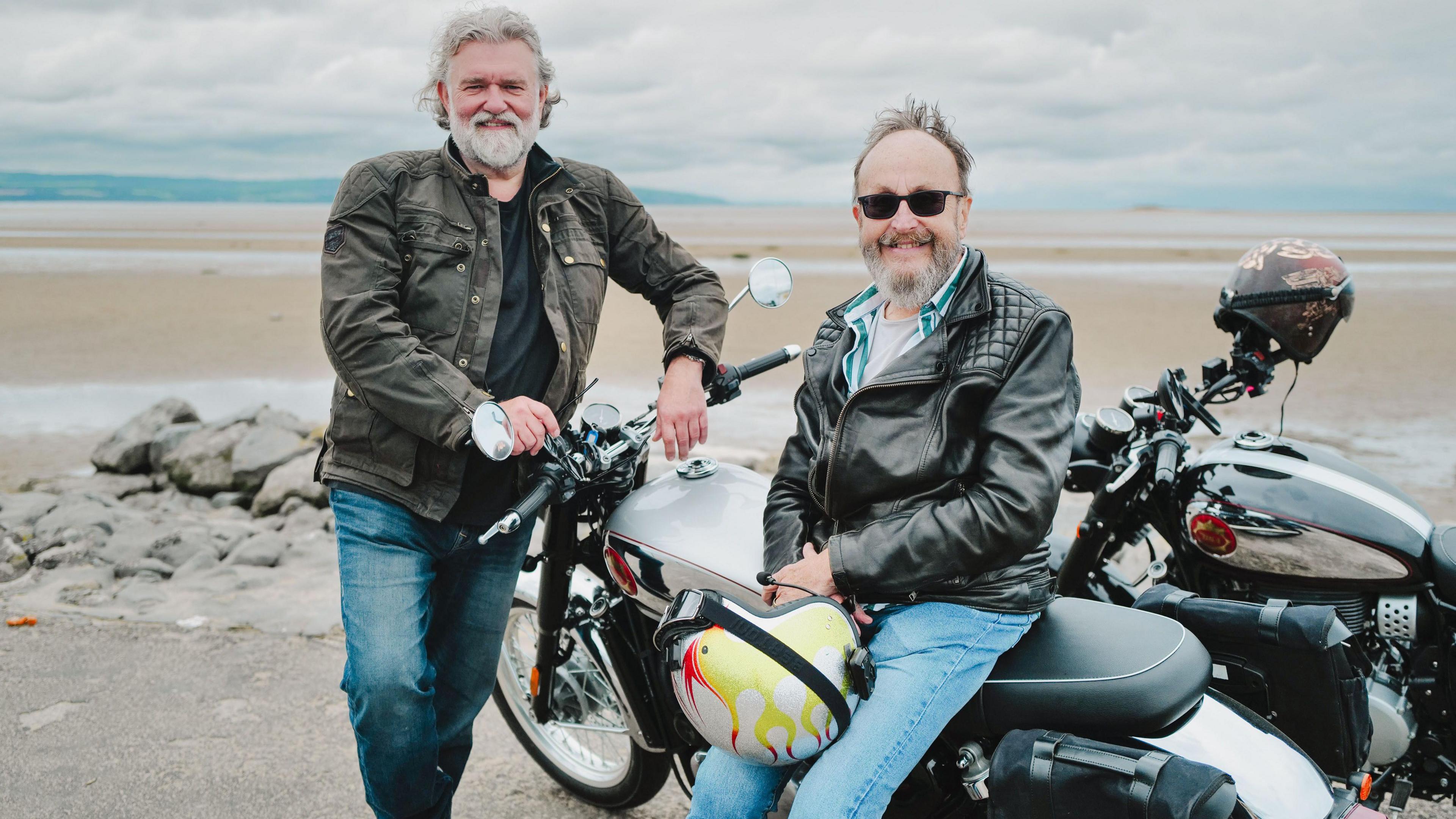 Si King and Dave Myers posing by their bikes on a beach