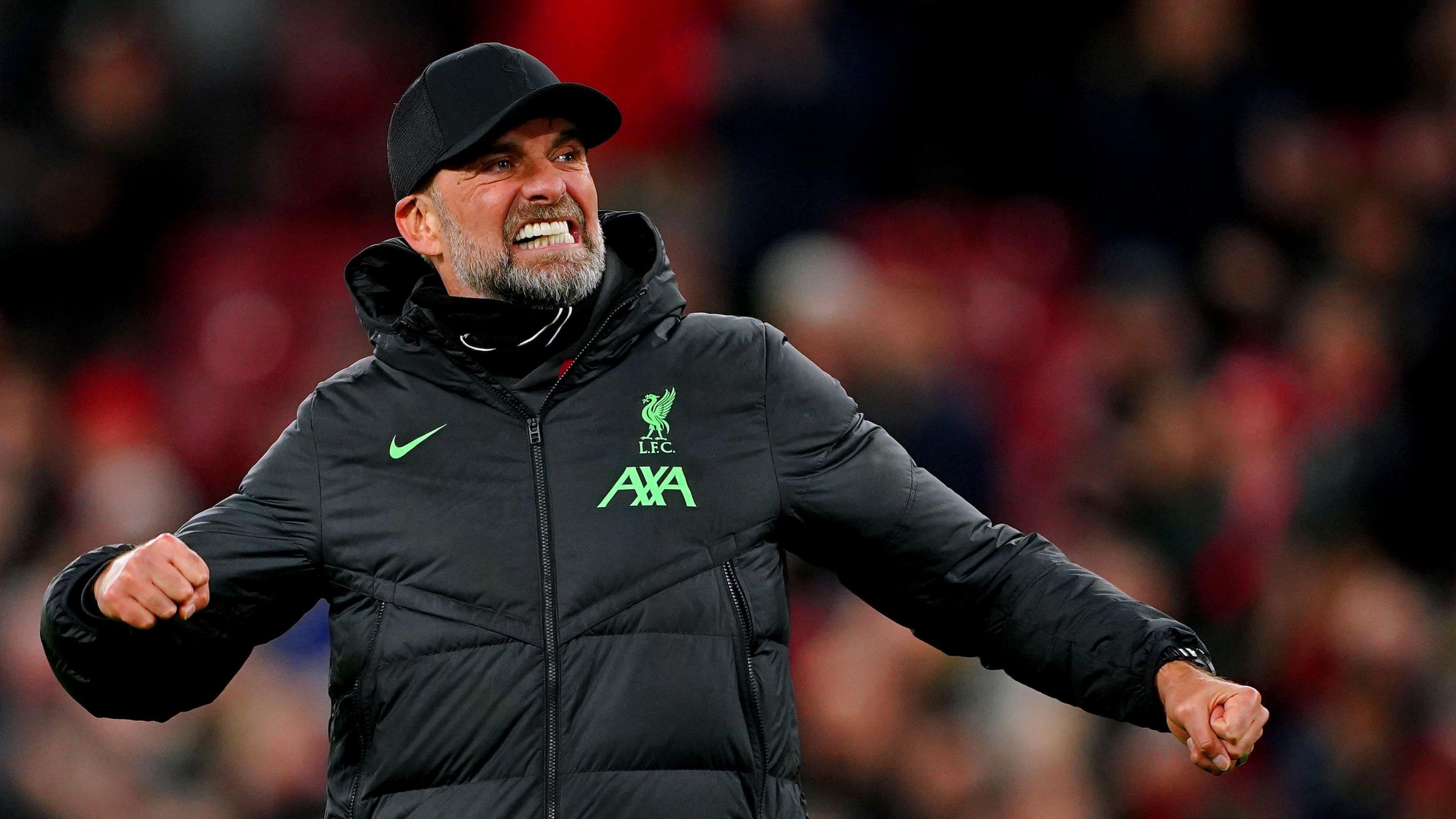 Jurgen Klopp in Liverpool FC matchday attire and trademark baseball cap, punching the air