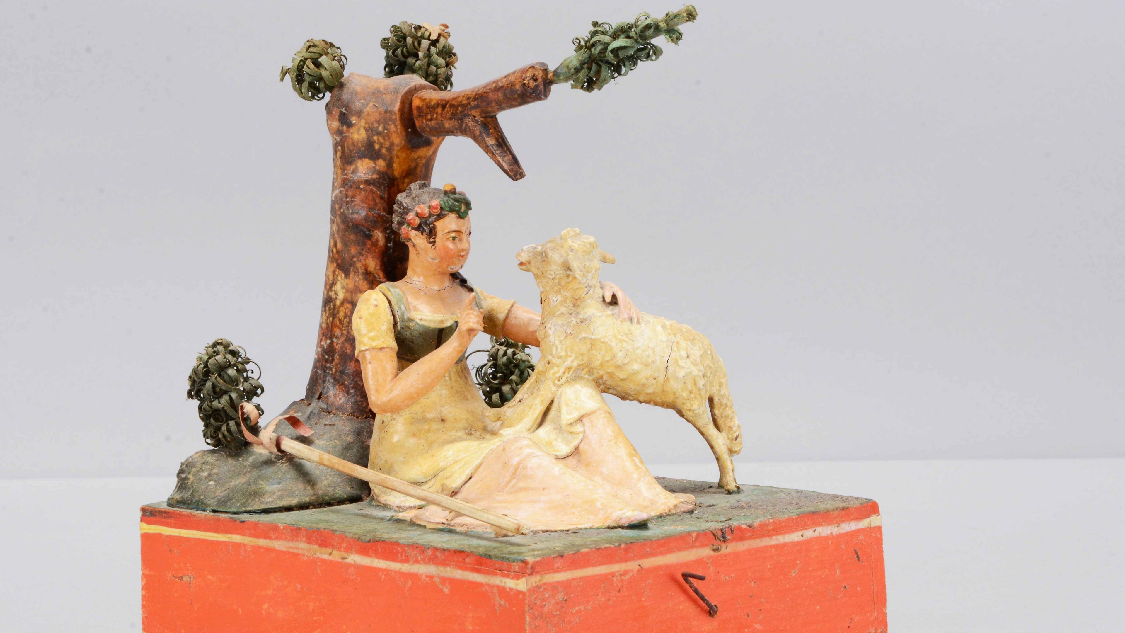 A Sonneberg  papier-mache and wood hand-cranked mechanical toy of a shepherdess.

