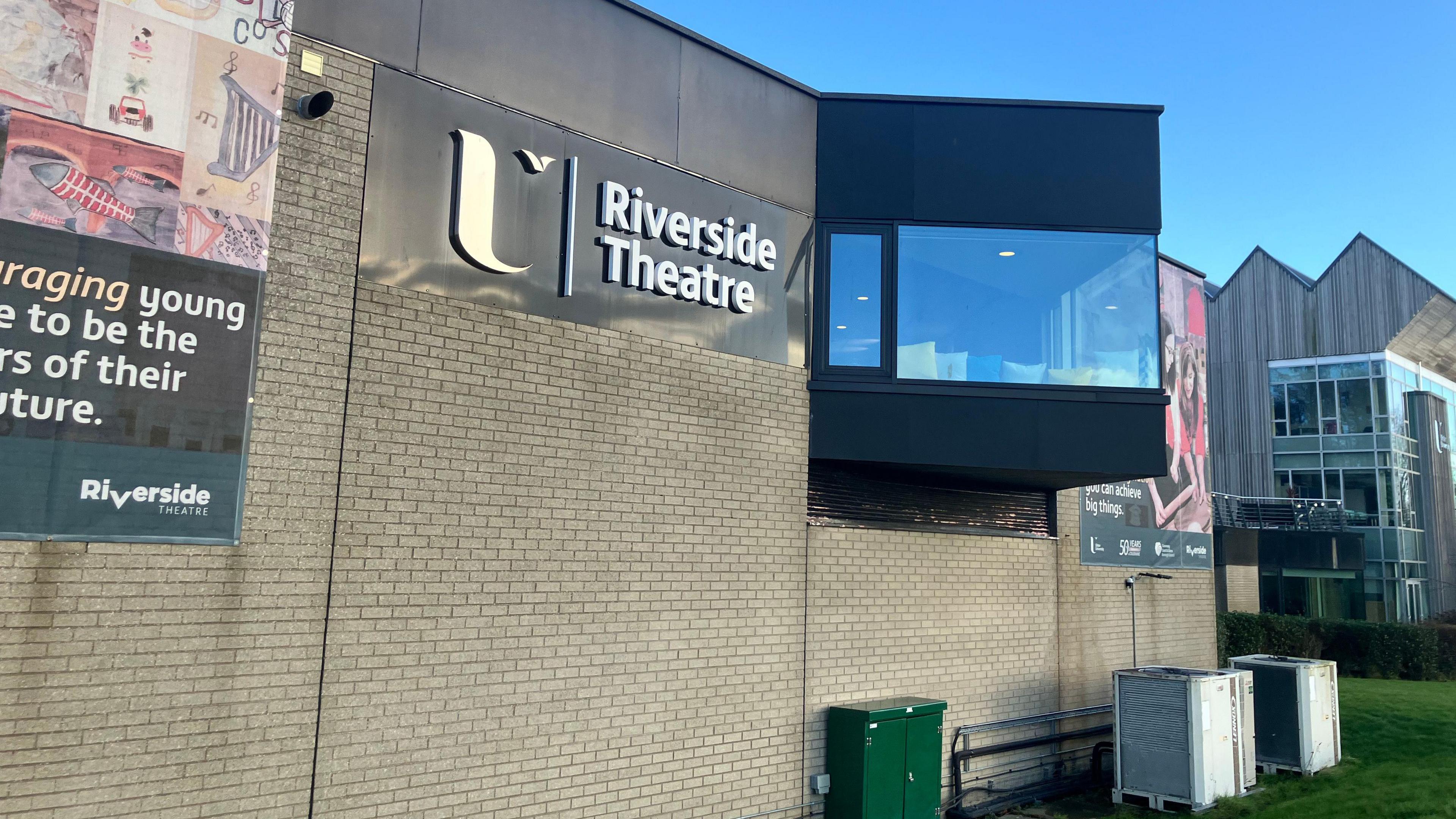The Riverside Theatre building on the Coleraine campus. A number of banners are seen on the outside of the building.