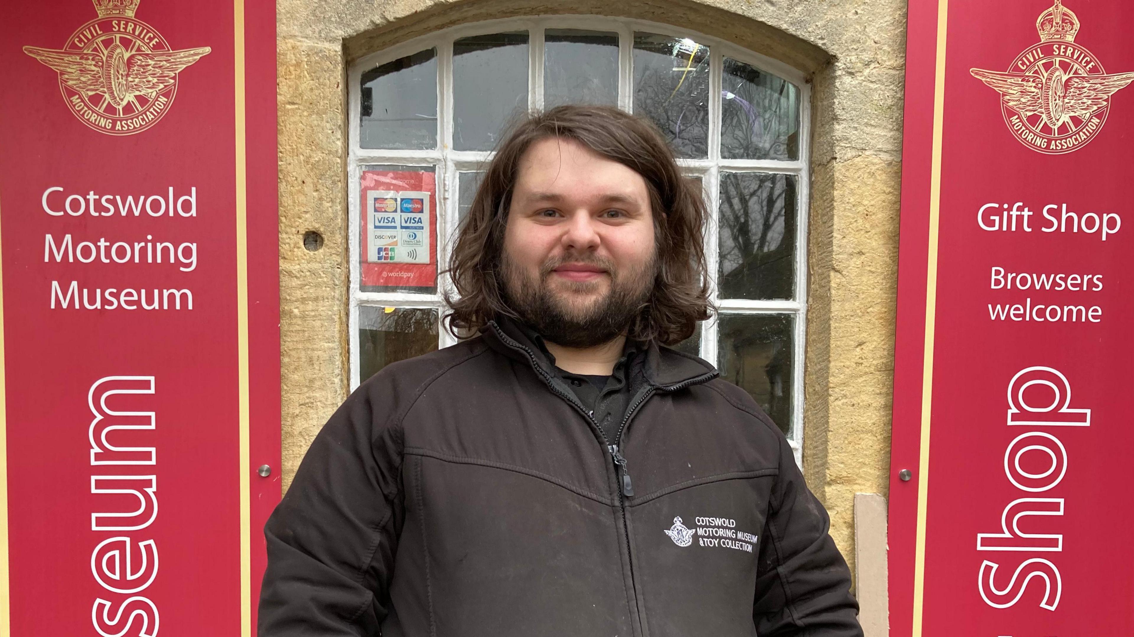 A photo of Adam Grime stood outside the front of the Motor Museum in Bourton-on-the-Water.