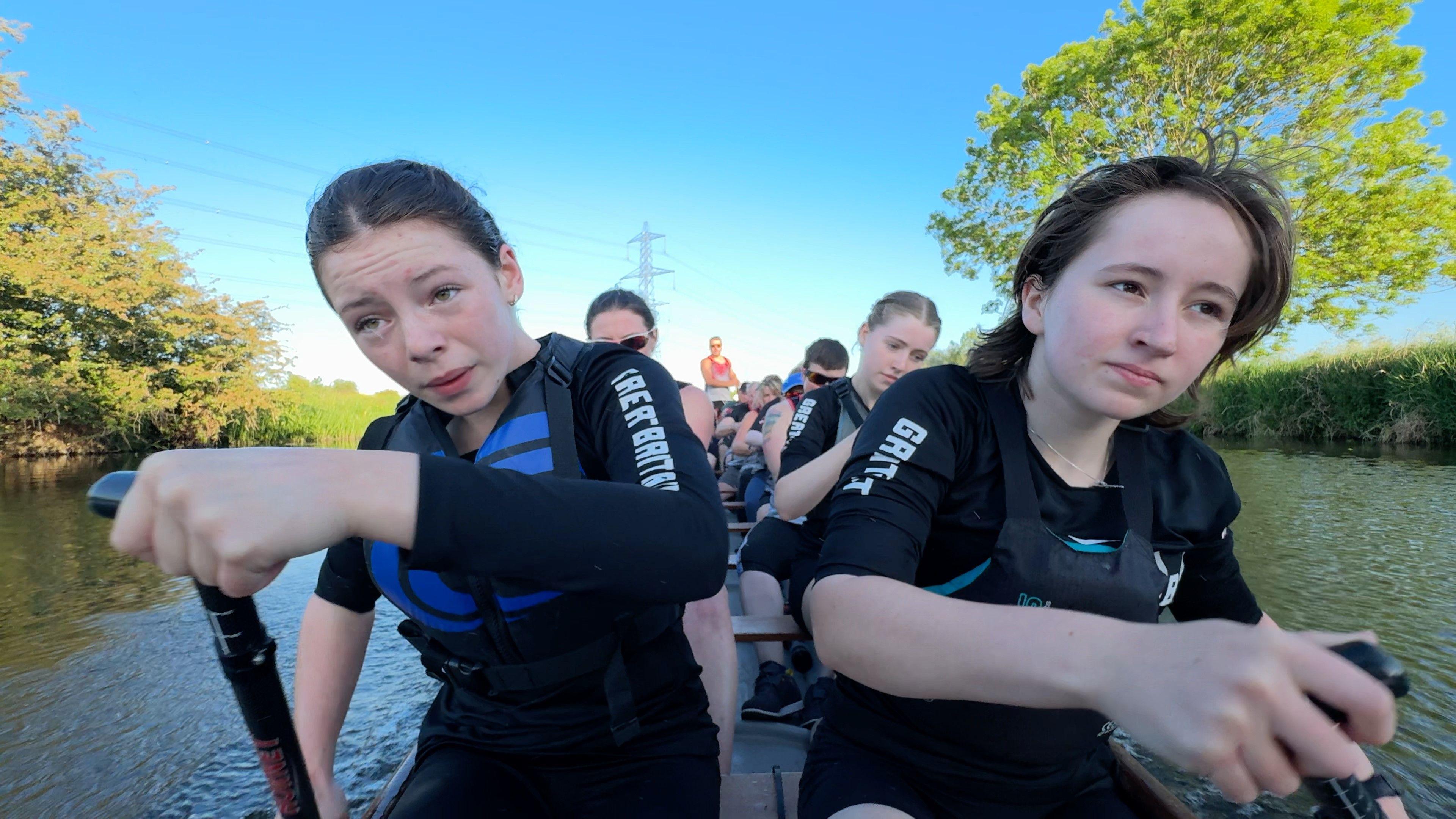 An image of young rowers paddling a dragon boat.