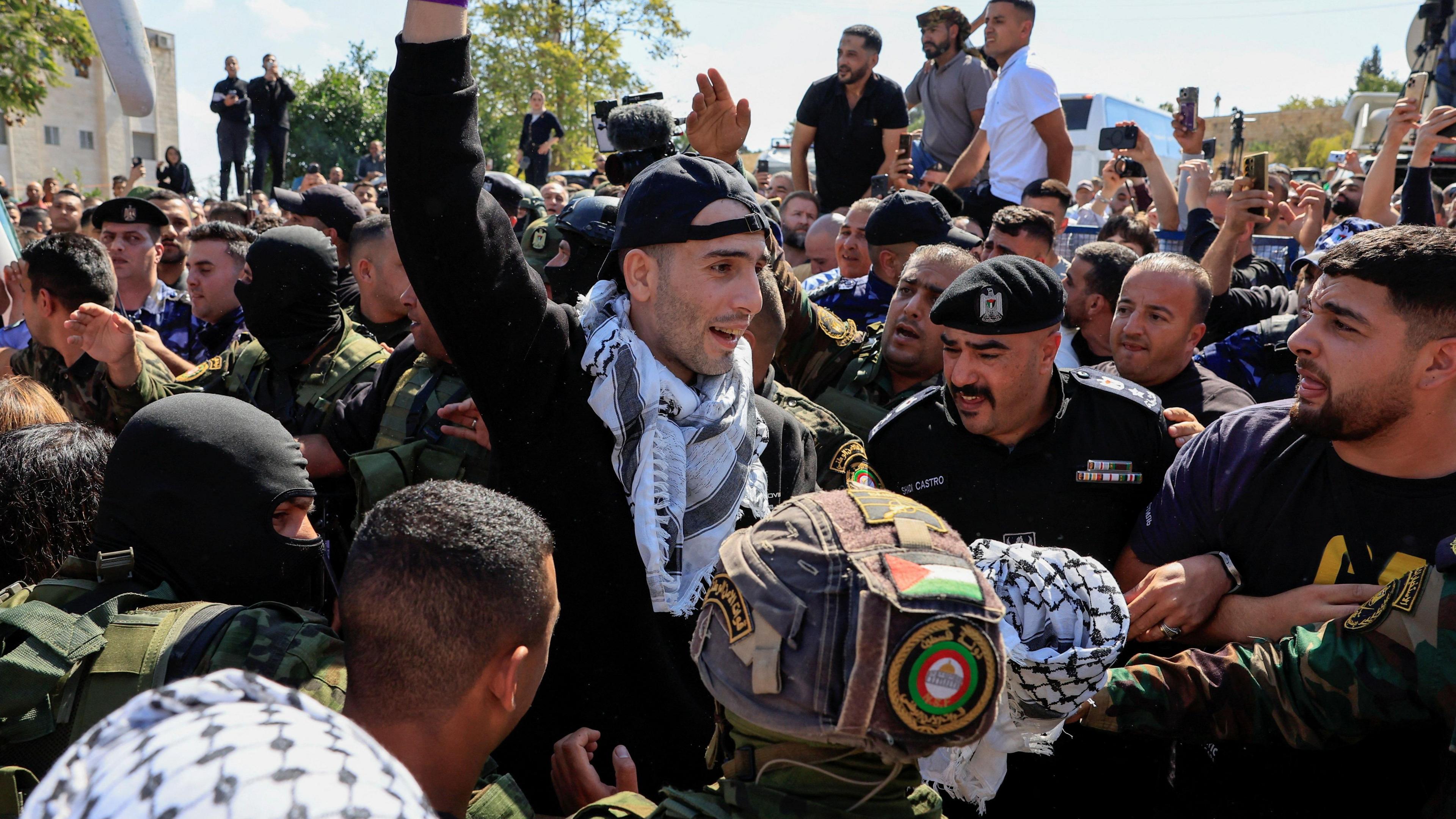 A prisoner holds his hands in the air after release. 