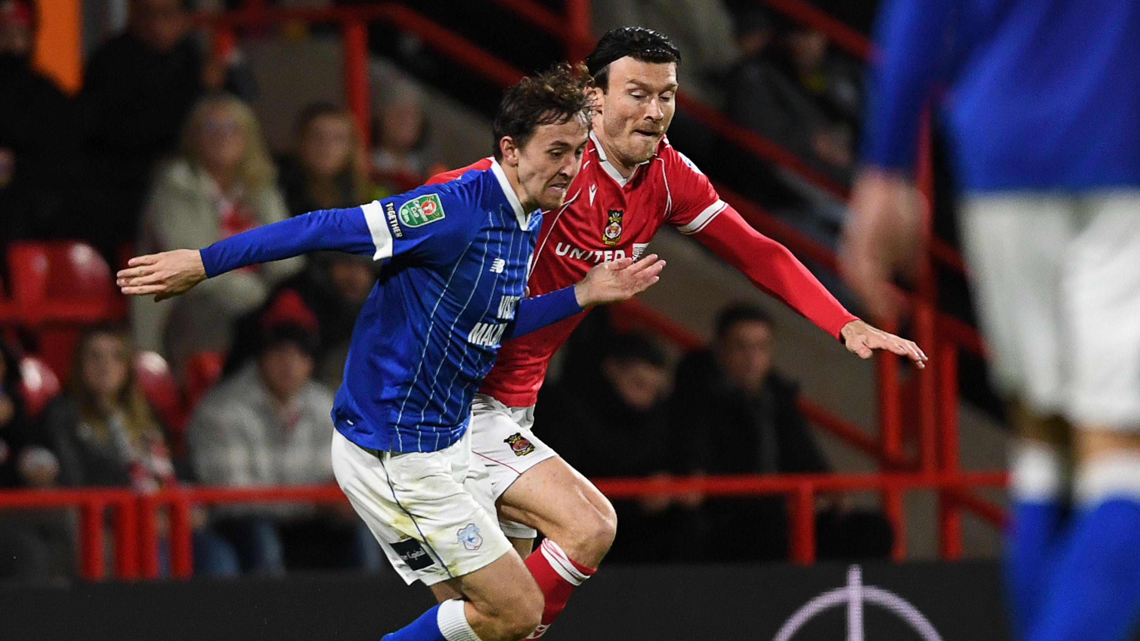 Cardiff's Ryan Wintle and Wrexham's Kieffer Moore competing 