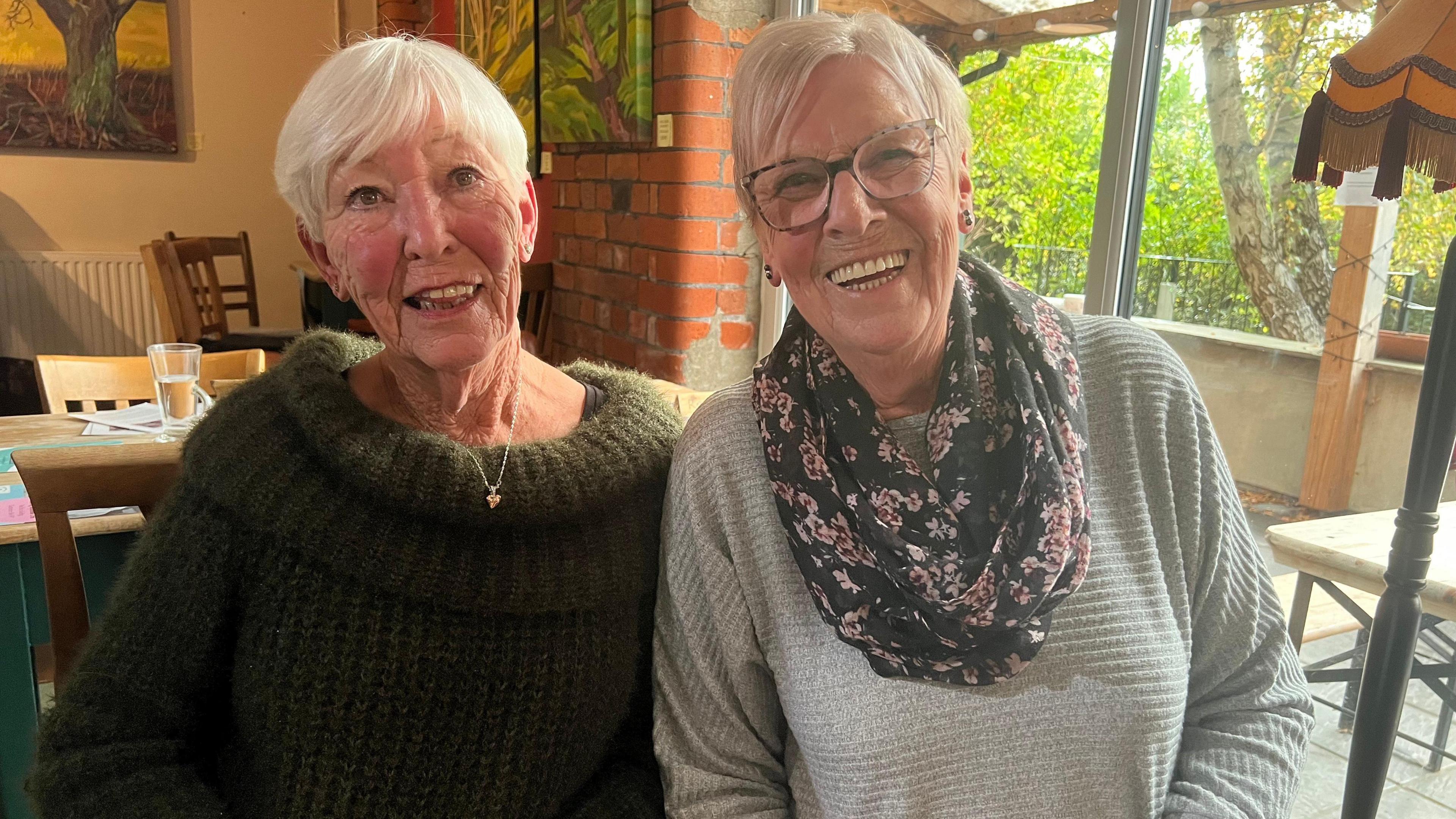 Jo and Pauline at the reunion cafe meet up smiling and laughing at the camera