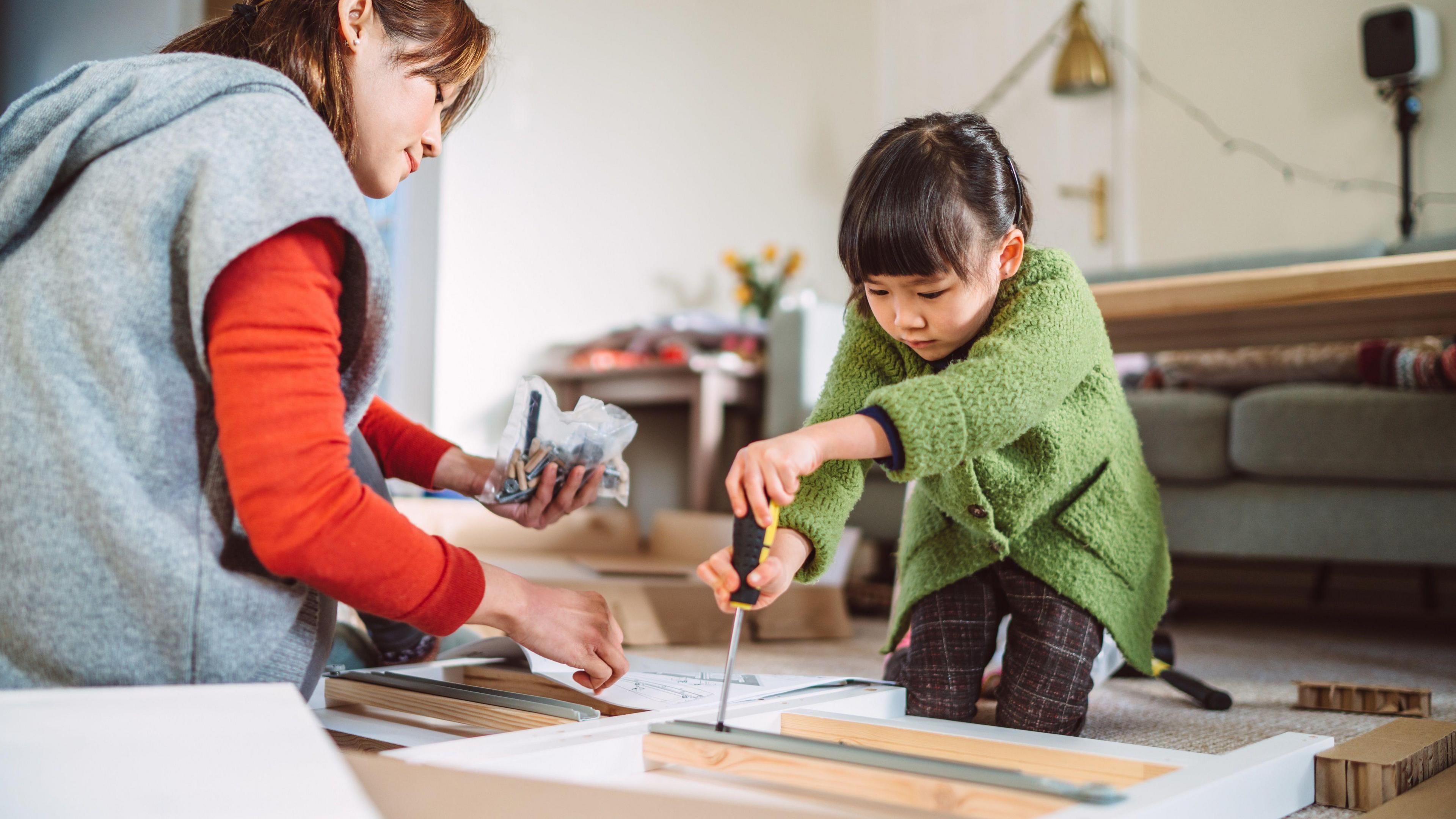 A girl and her mother assembling flatpack furniture