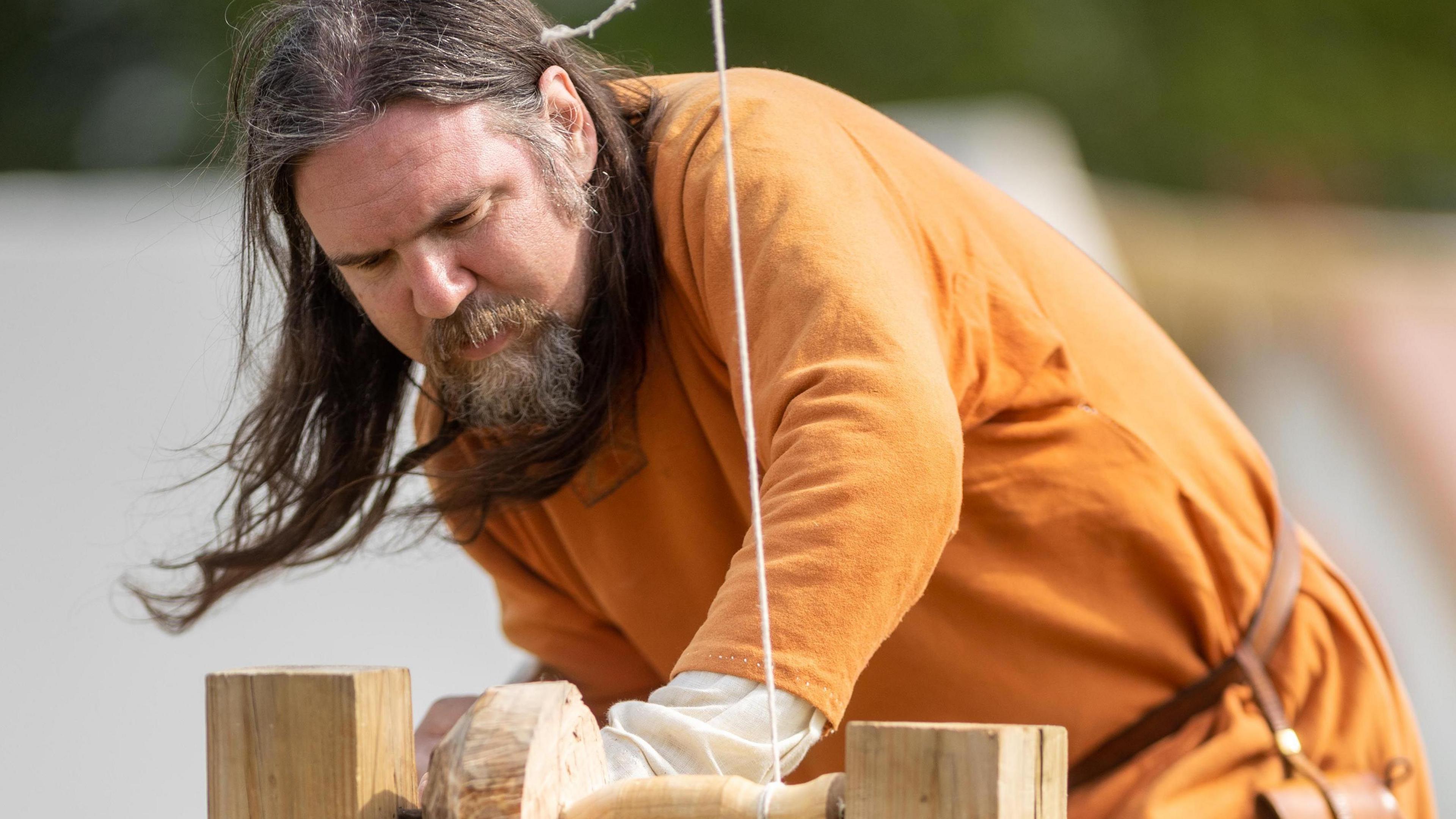 Viking re-enactor working a lathe