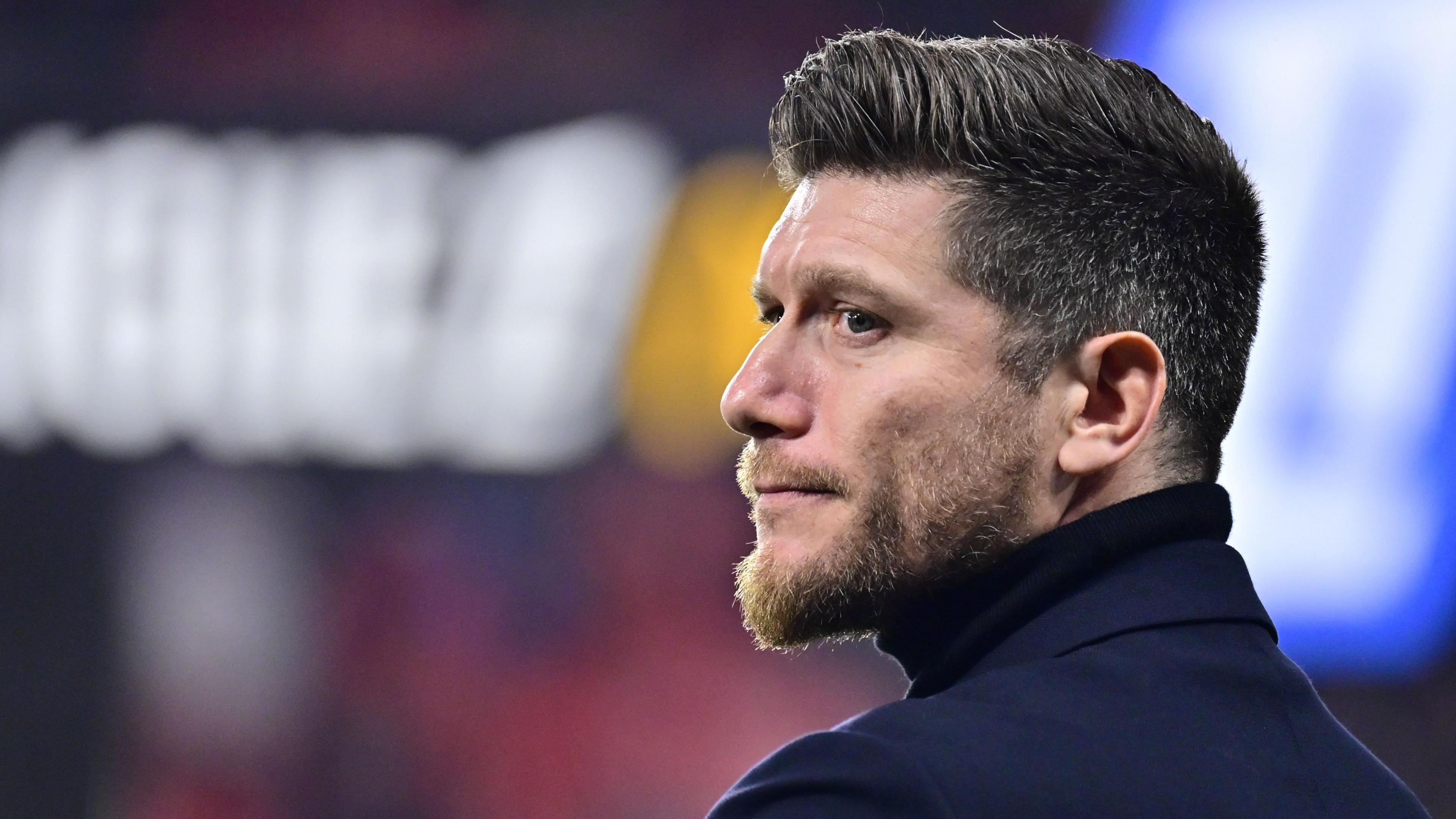 Sebastien Pocognoli, pictured wearing a roll neck top, looks across to his left