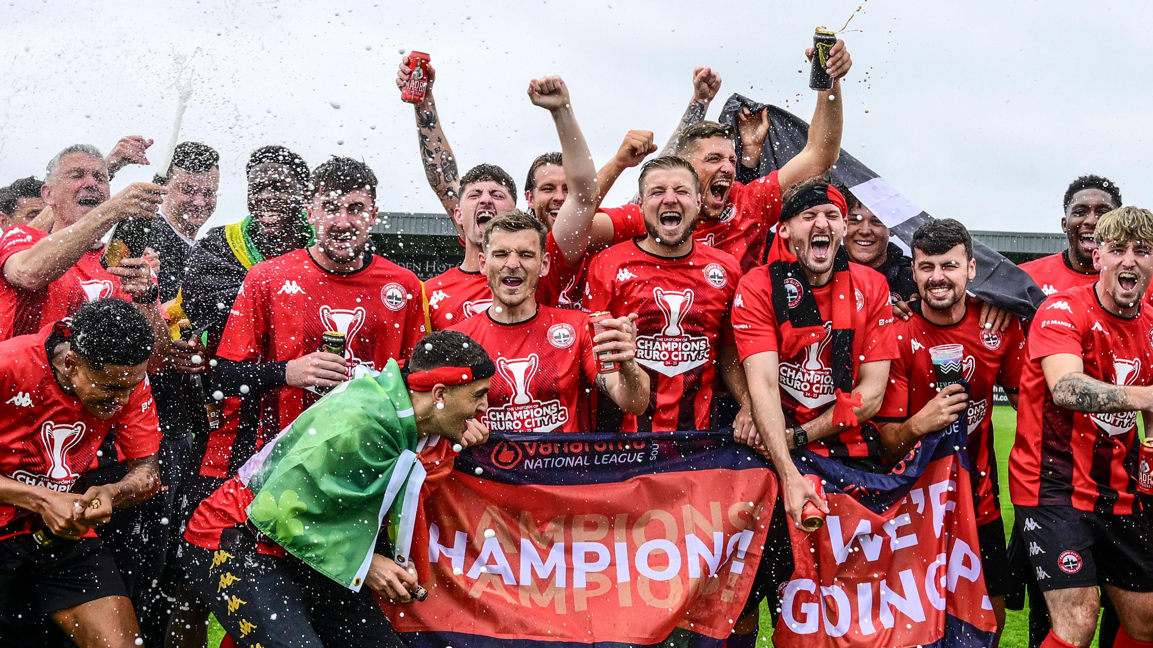 Truro City spray champagne on the pitch after winning National League South title in April