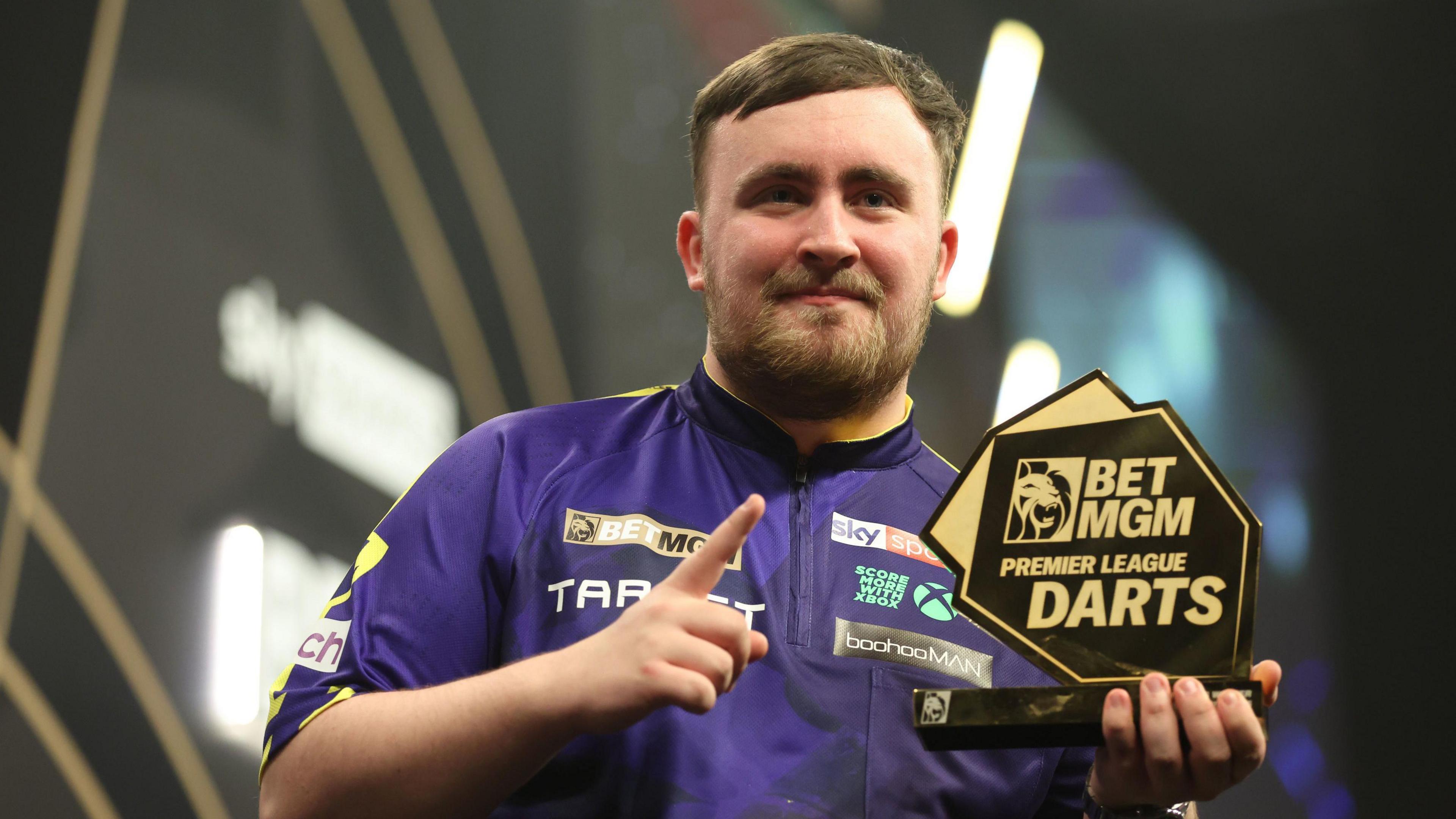 Luke Littler with the trophy in Sheffield