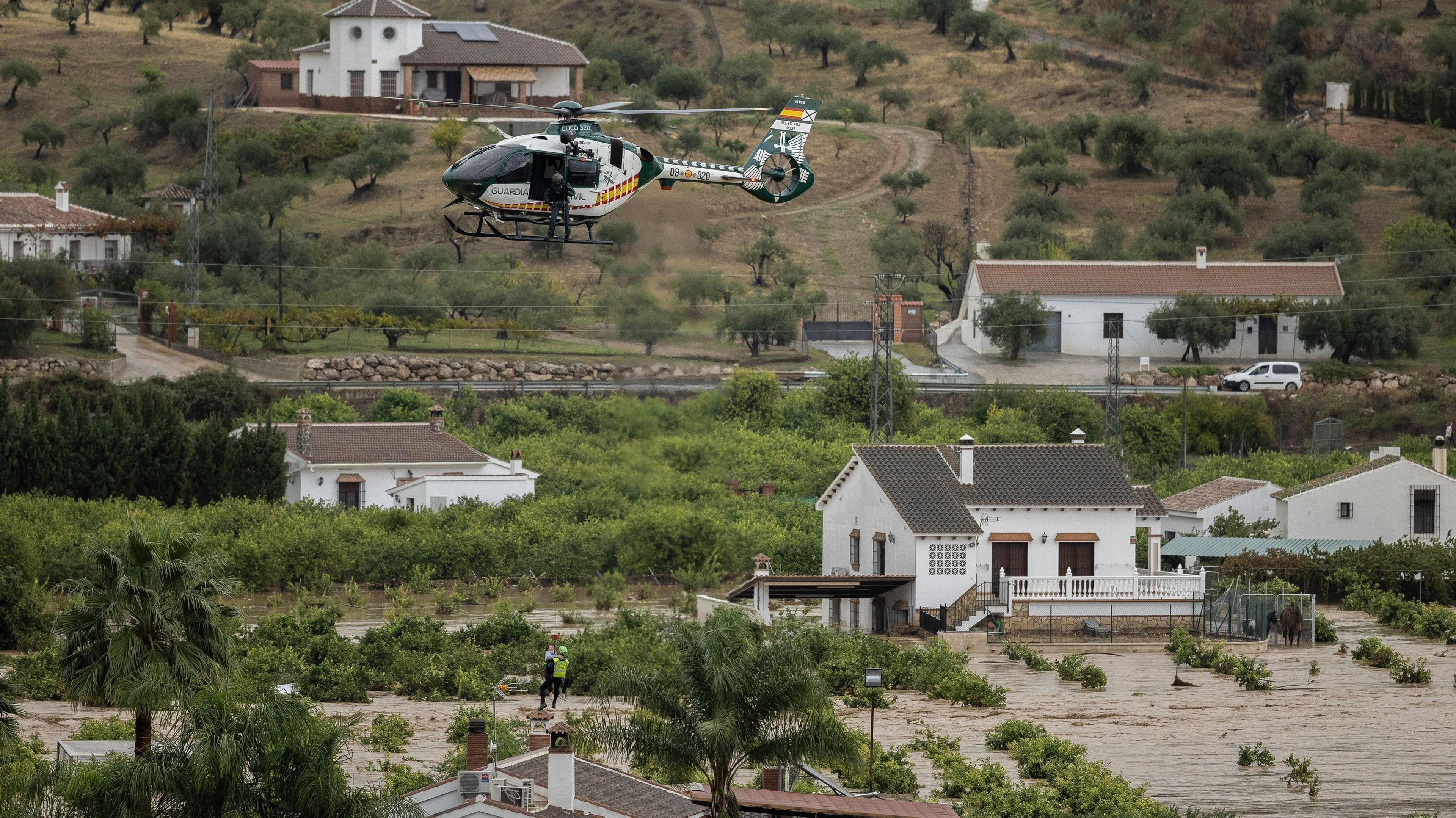 emergency service helicopter flying over flood water.