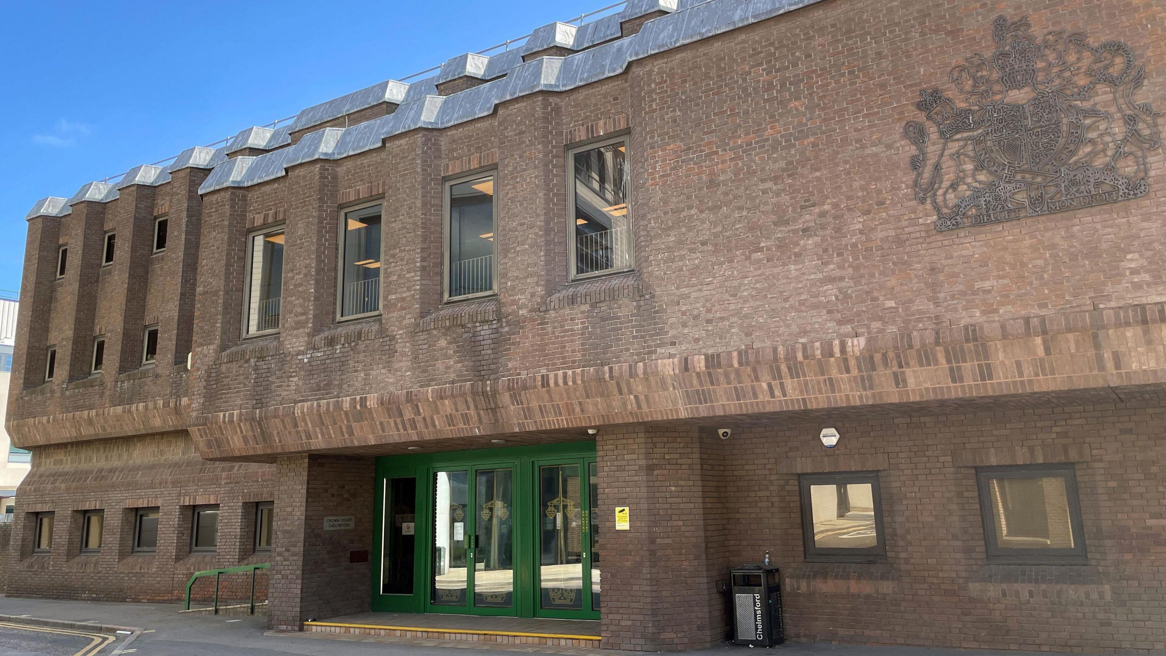 The exterior of Chelmsford Crown Court, which is a brick building with green doors.