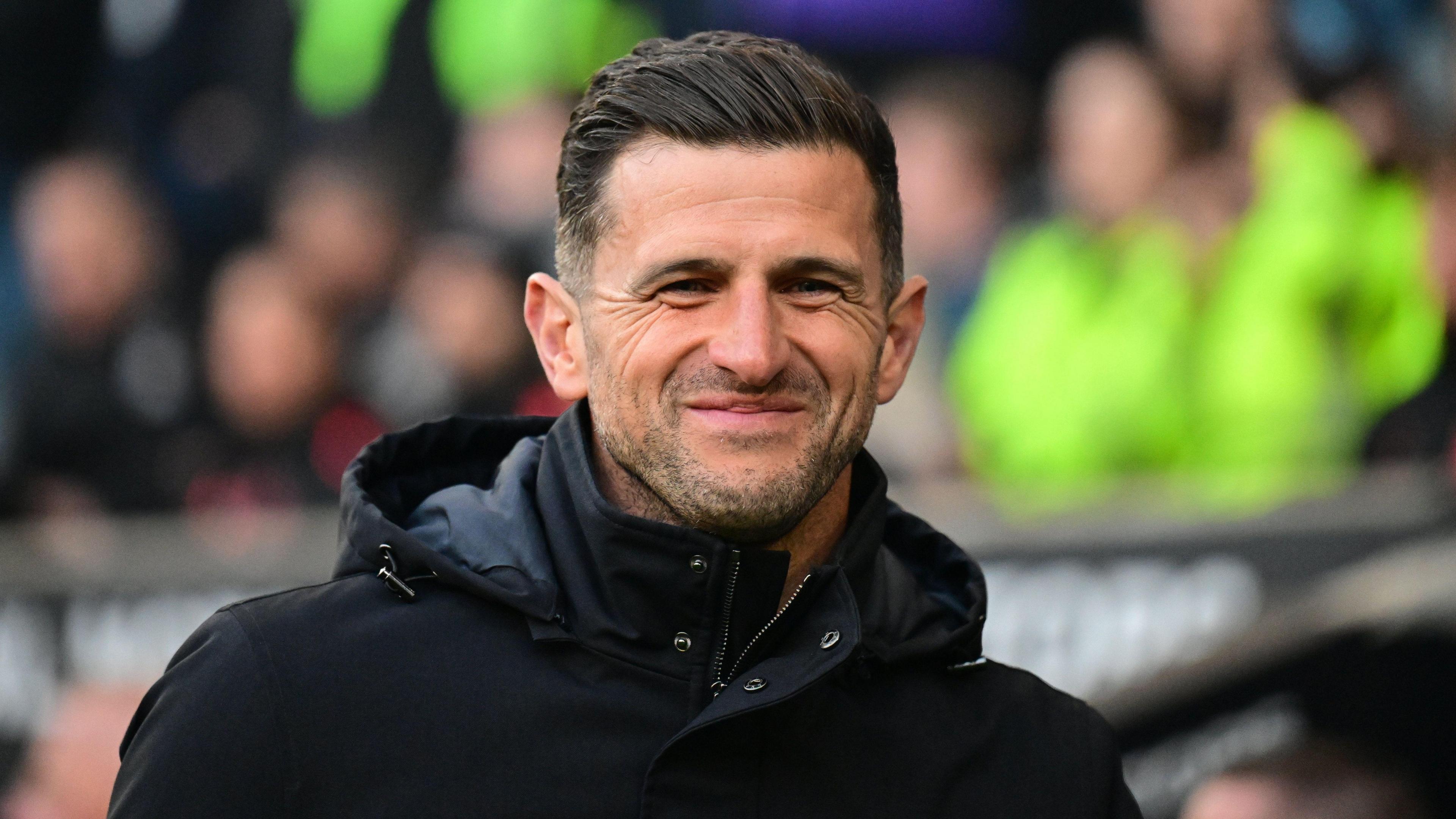 John Mousinho smiling on the Portsmouth touchline